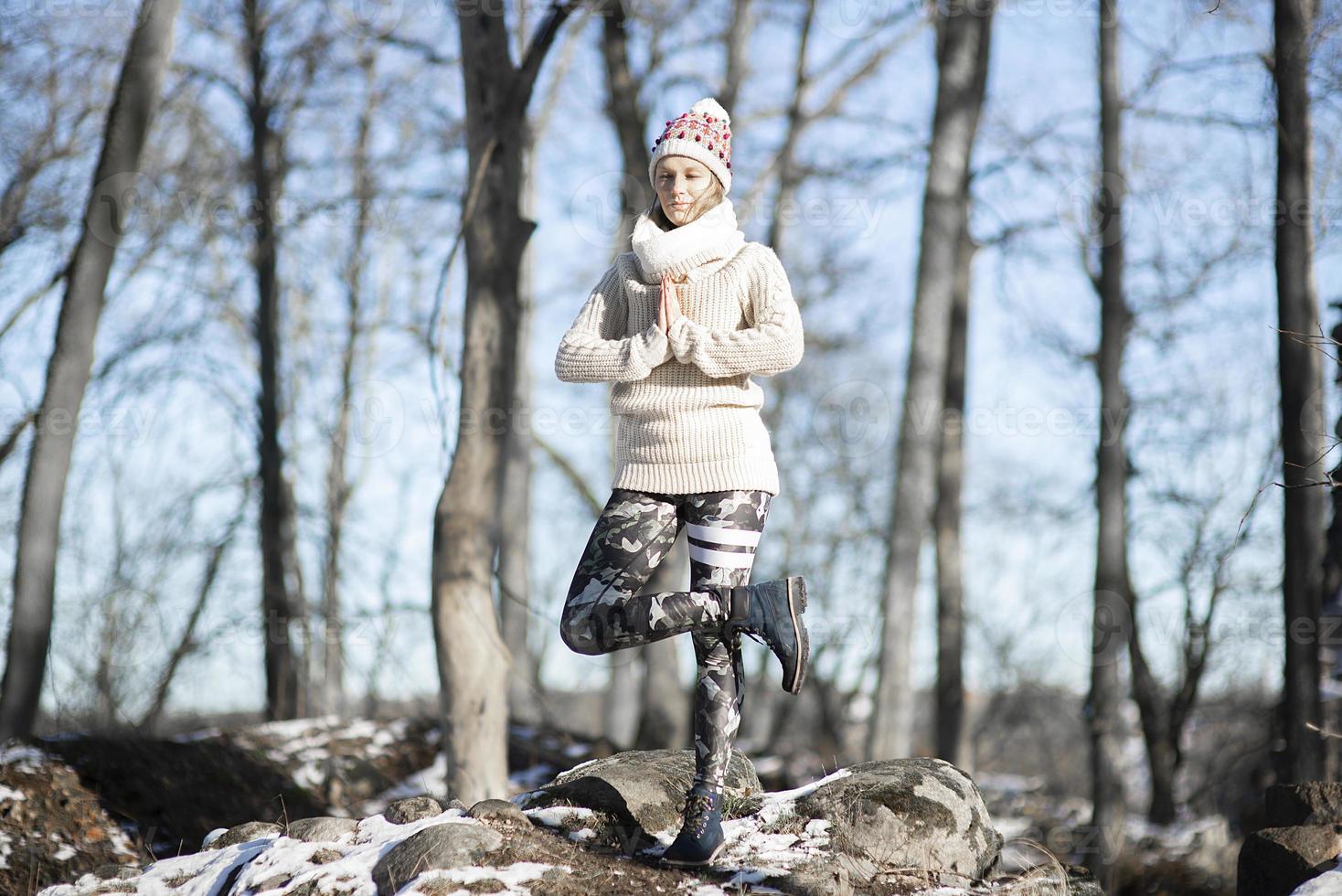 A young athletic woman performs yoga and meditation exercises outdoors photo