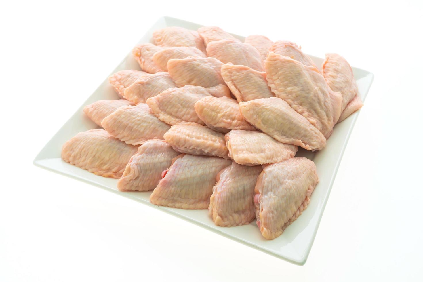 Raw chicken wings on white plate photo