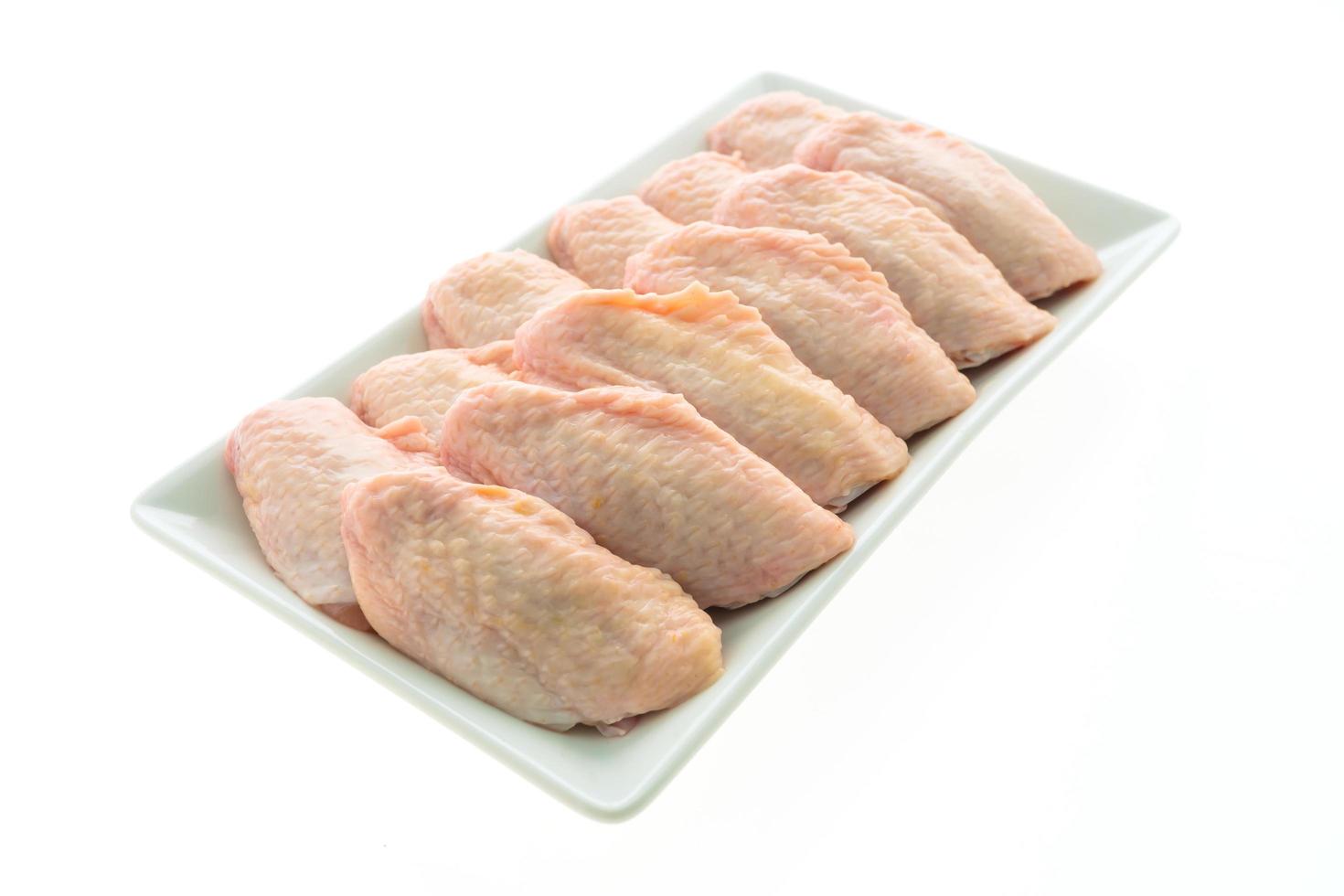 Raw chicken wings on white plate photo