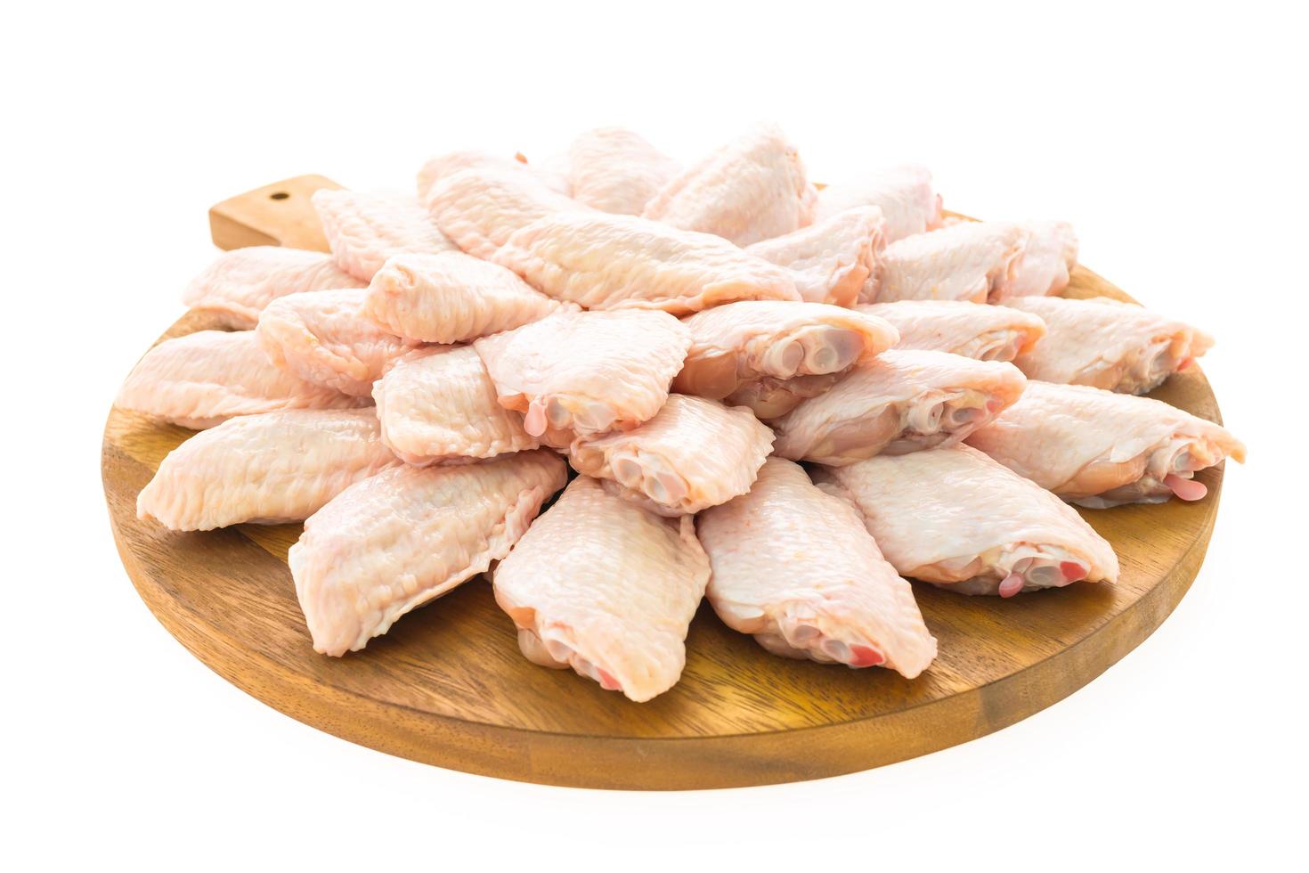 Raw chicken wings on wooden plate photo