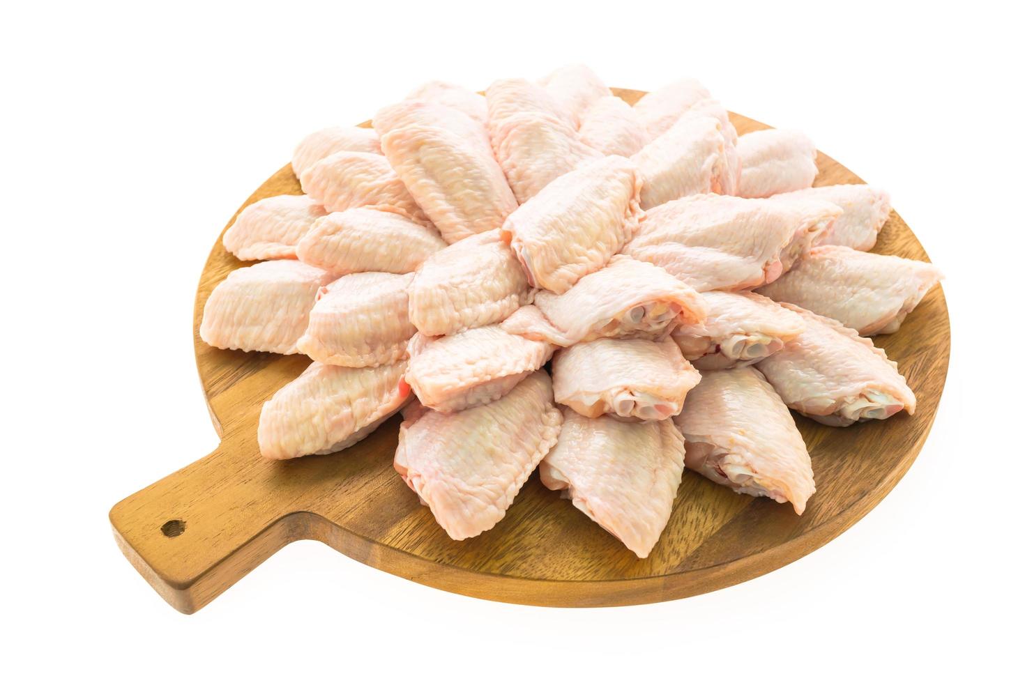 Raw chicken wings on wooden plate photo