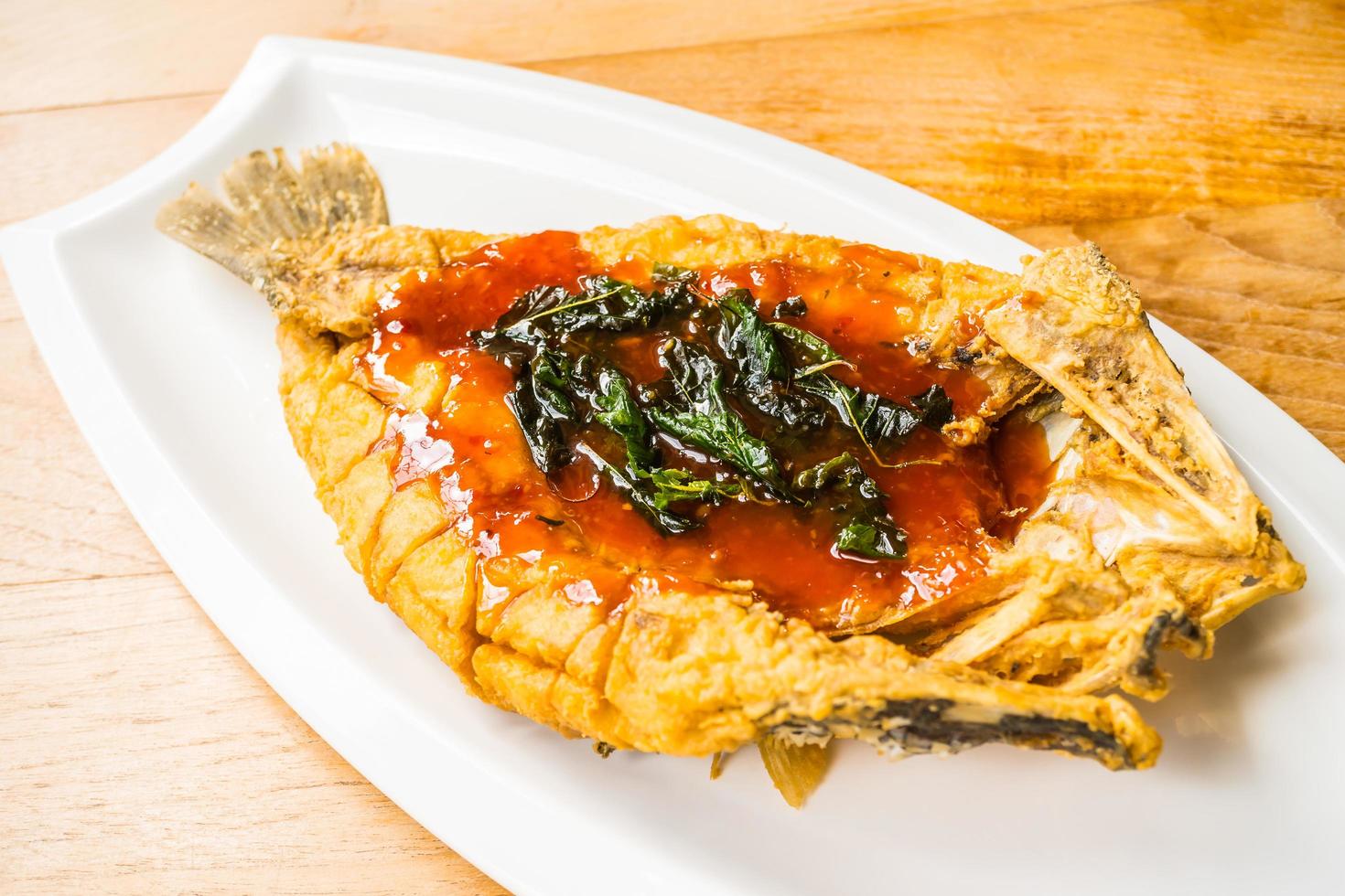 Fried sea bass fish on white plate photo