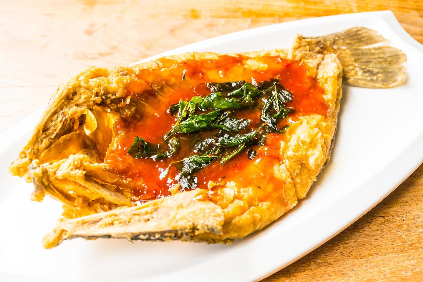 Pescado de lubina frito en un plato blanco foto