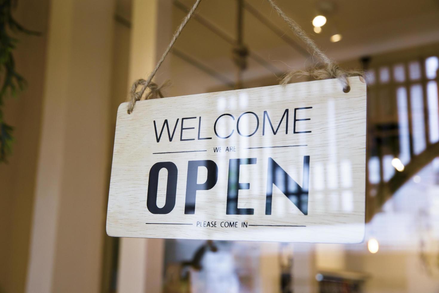 Bienvenido cartel abierto en una puerta foto