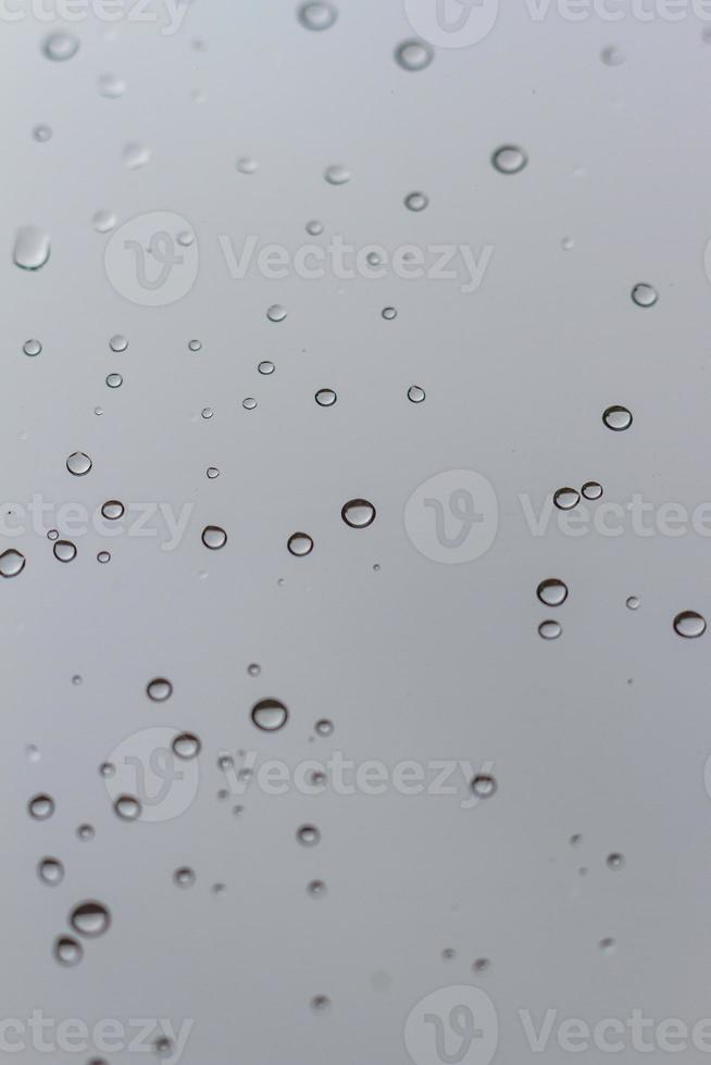 Gotas de agua sobre un fondo vertical de vidrio foto