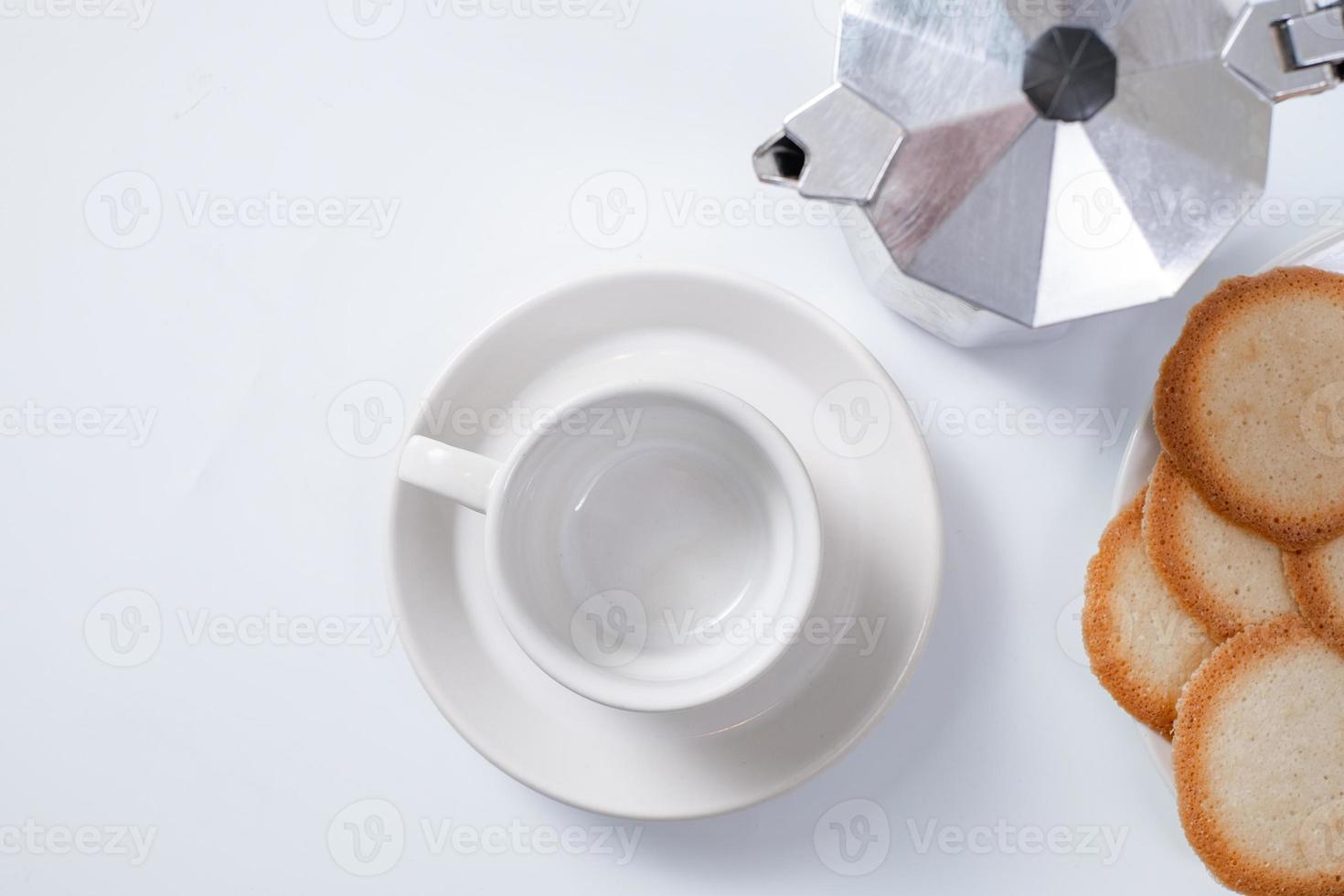 Taza de café vacía con galletas sobre fondo blanco. foto