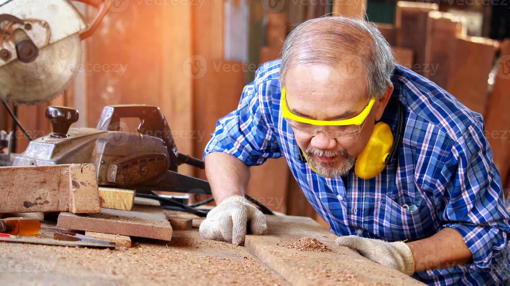 Carpenter sawing wood photo