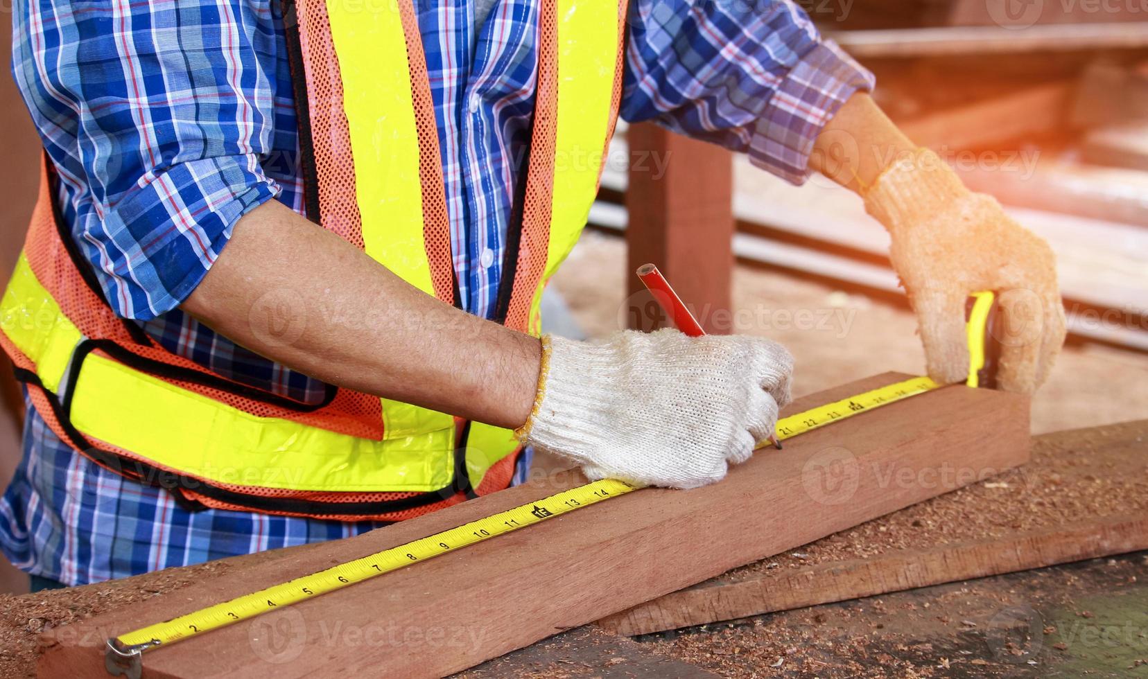 Carpenter measuring wood photo