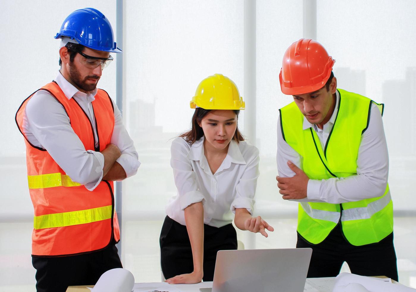 Grupo de ingenieros mirando un portátil. foto