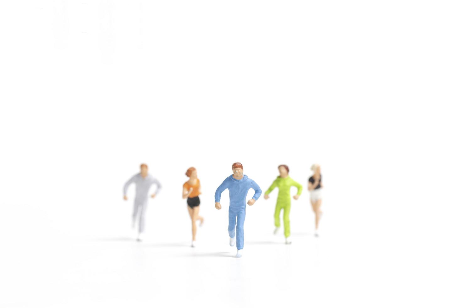 Miniature people running isolated on a white background photo