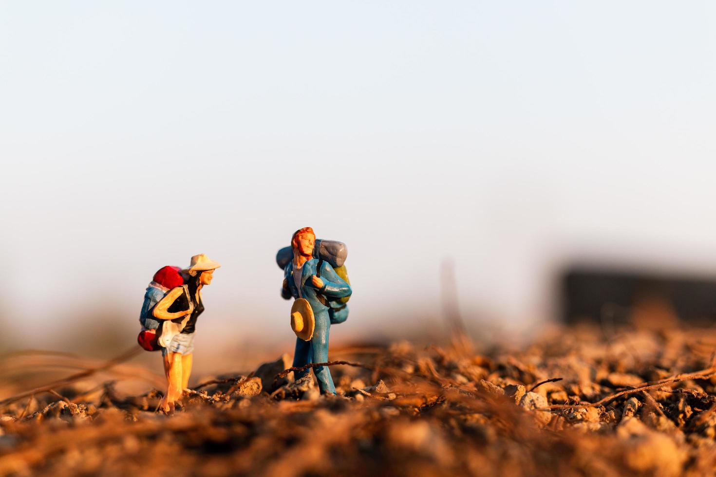 Viajeros en miniatura con mochilas de montañismo, senderismo y mochilero concepto al aire libre foto