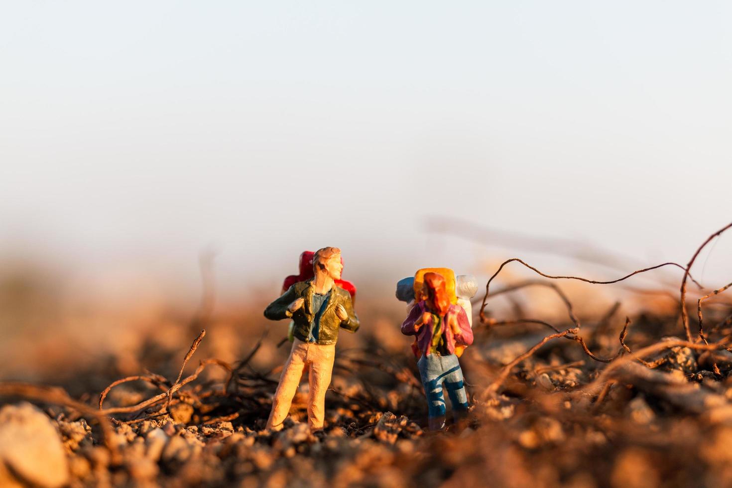 Viajeros en miniatura con mochilas de montañismo, senderismo y mochilero concepto al aire libre foto