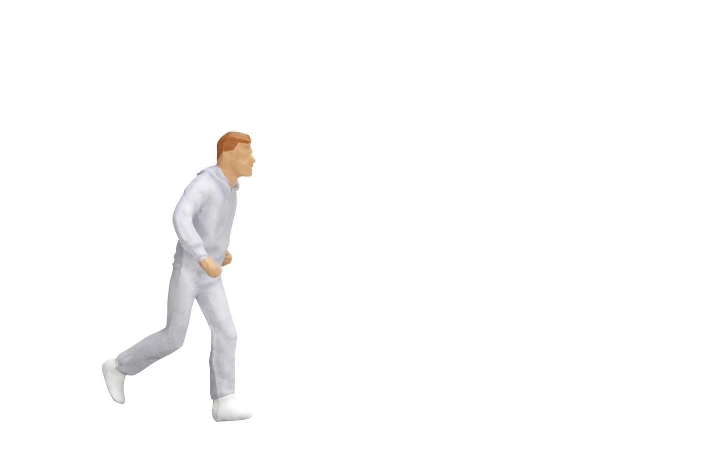 Miniature person running isolated on a white background photo