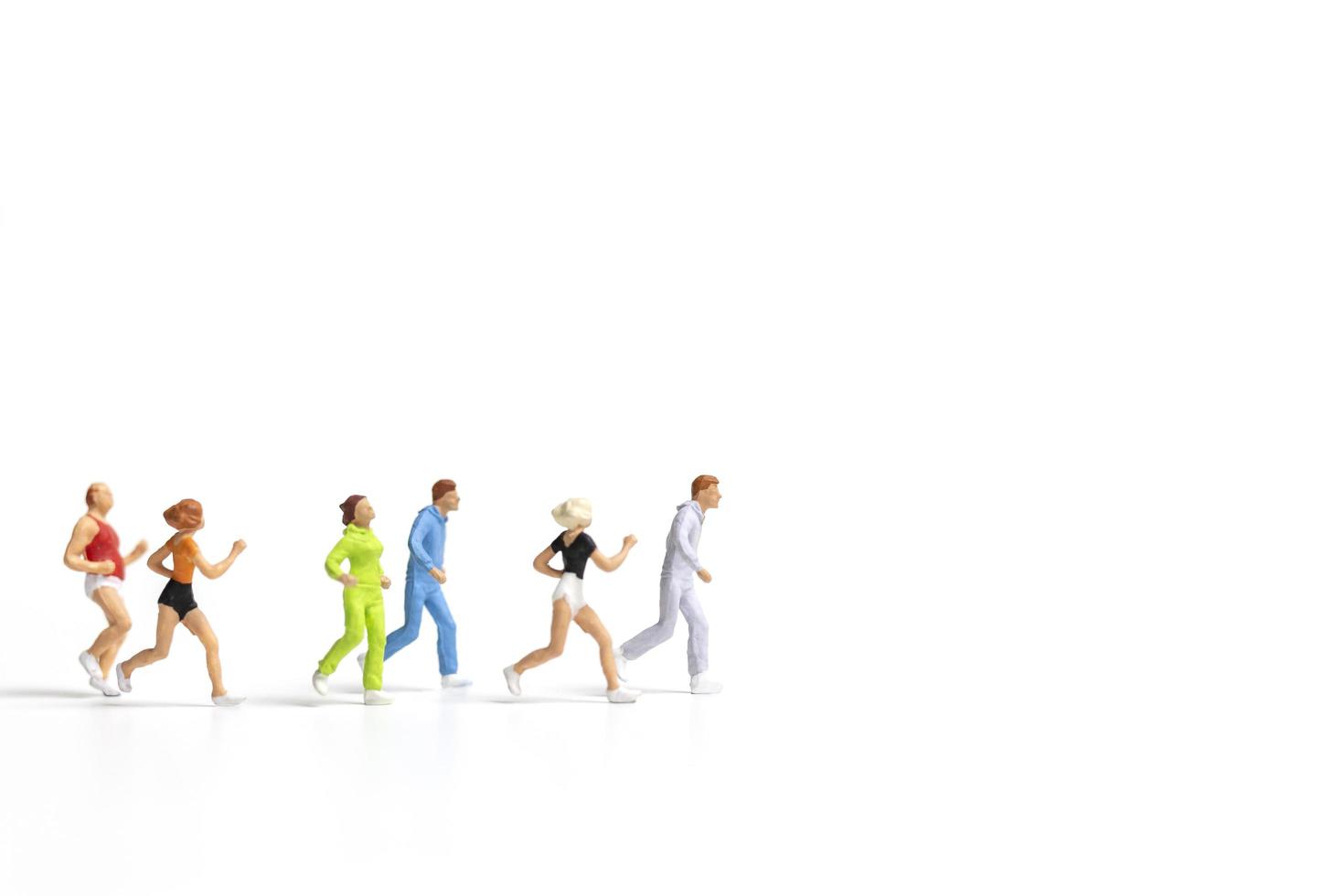 Miniature people running isolated on a white background photo