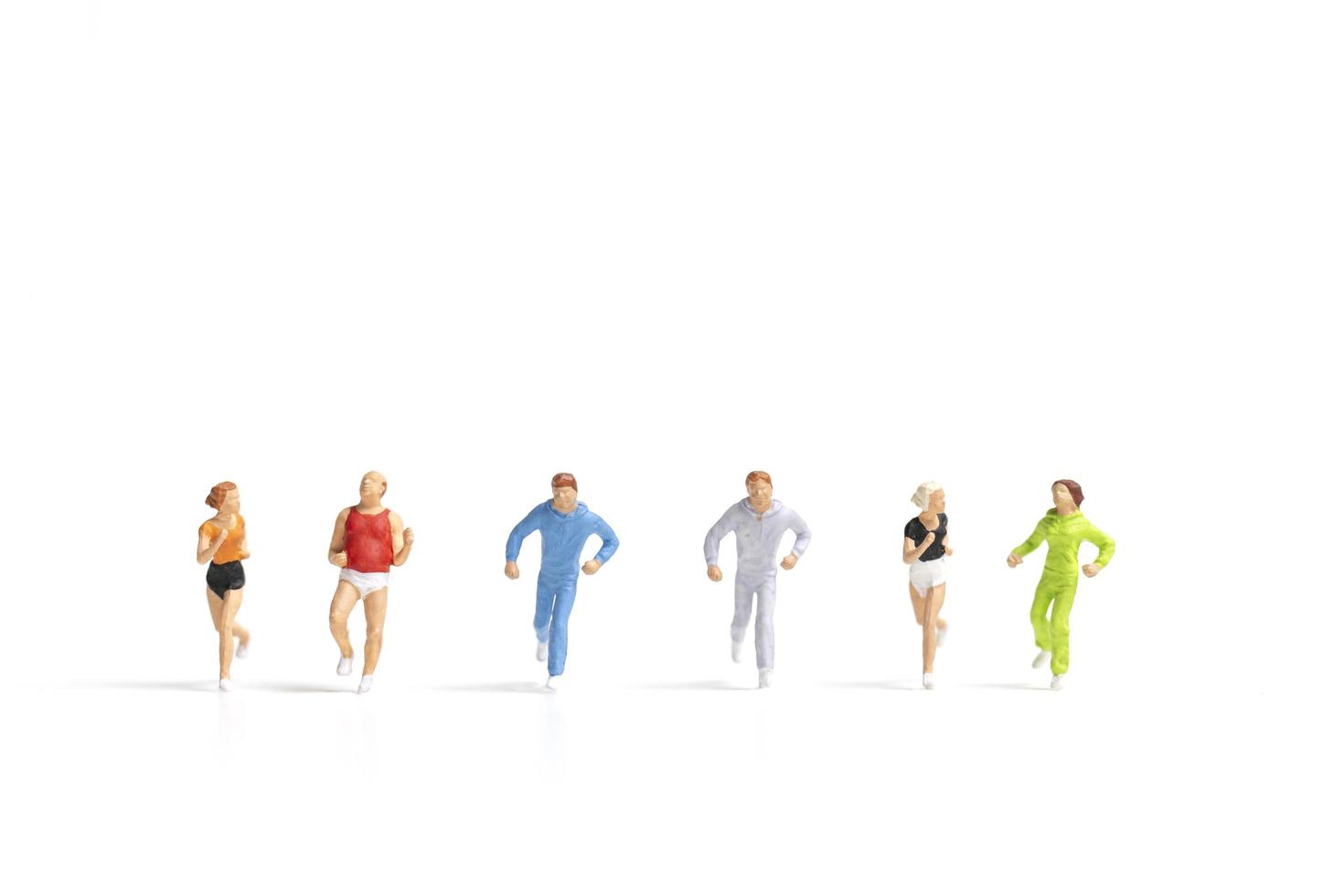 Miniature people running isolated on a white background photo