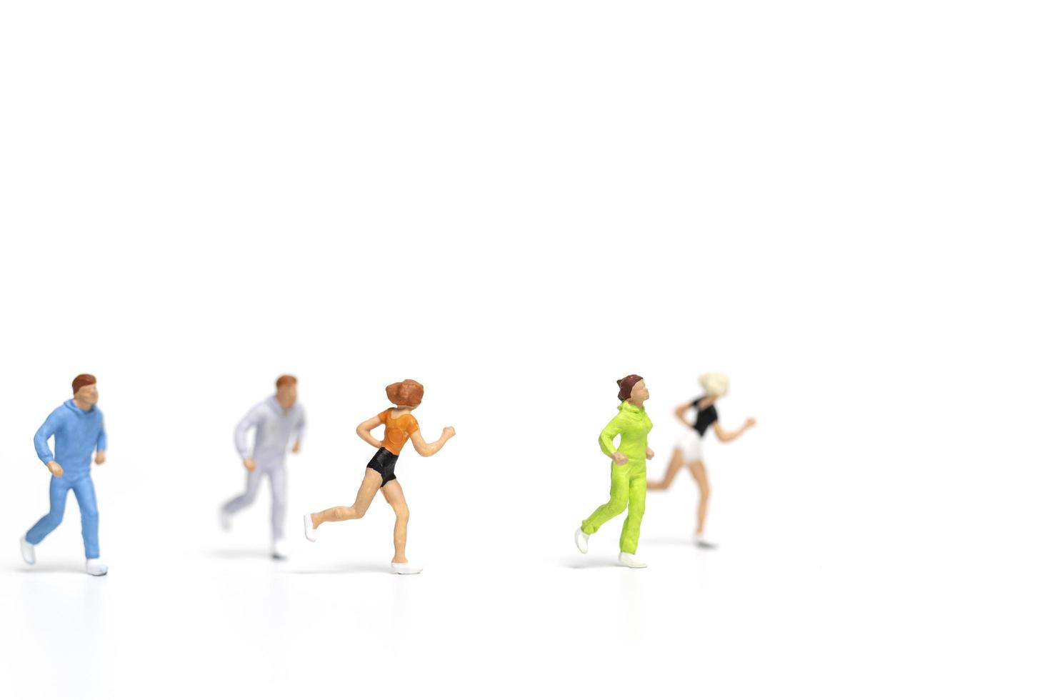 Miniature people running isolated on a white background photo