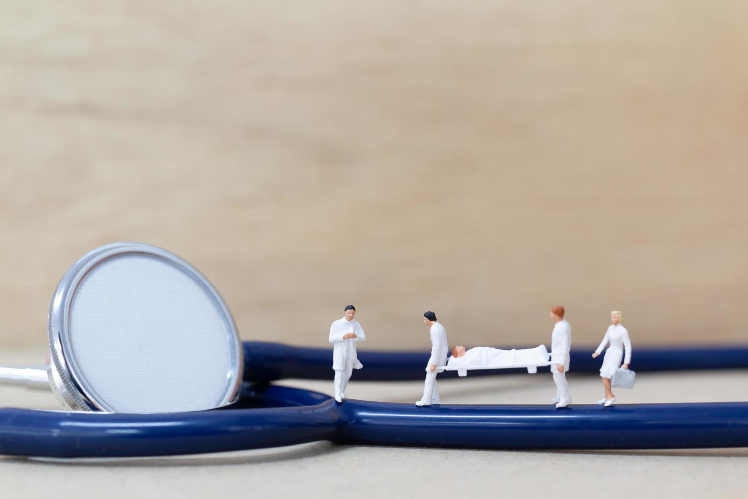 Miniature doctors with nurses carrying a patient on a stretcher, healthcare concept photo