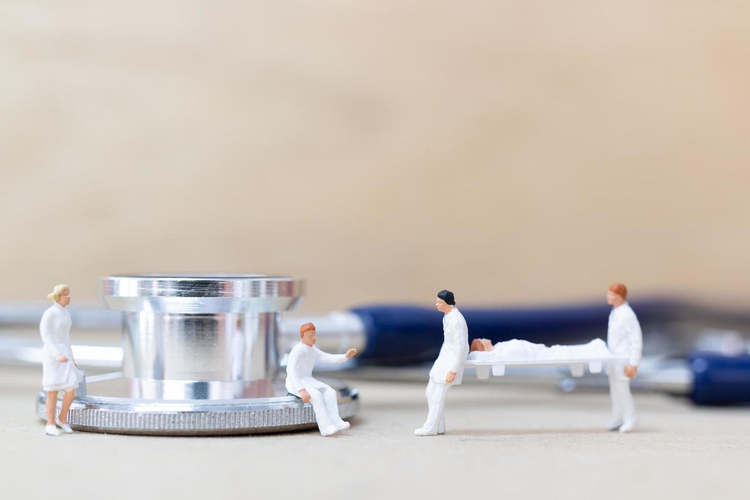 Miniature doctors with nurses carrying a patient on a stretcher, healthcare concept photo