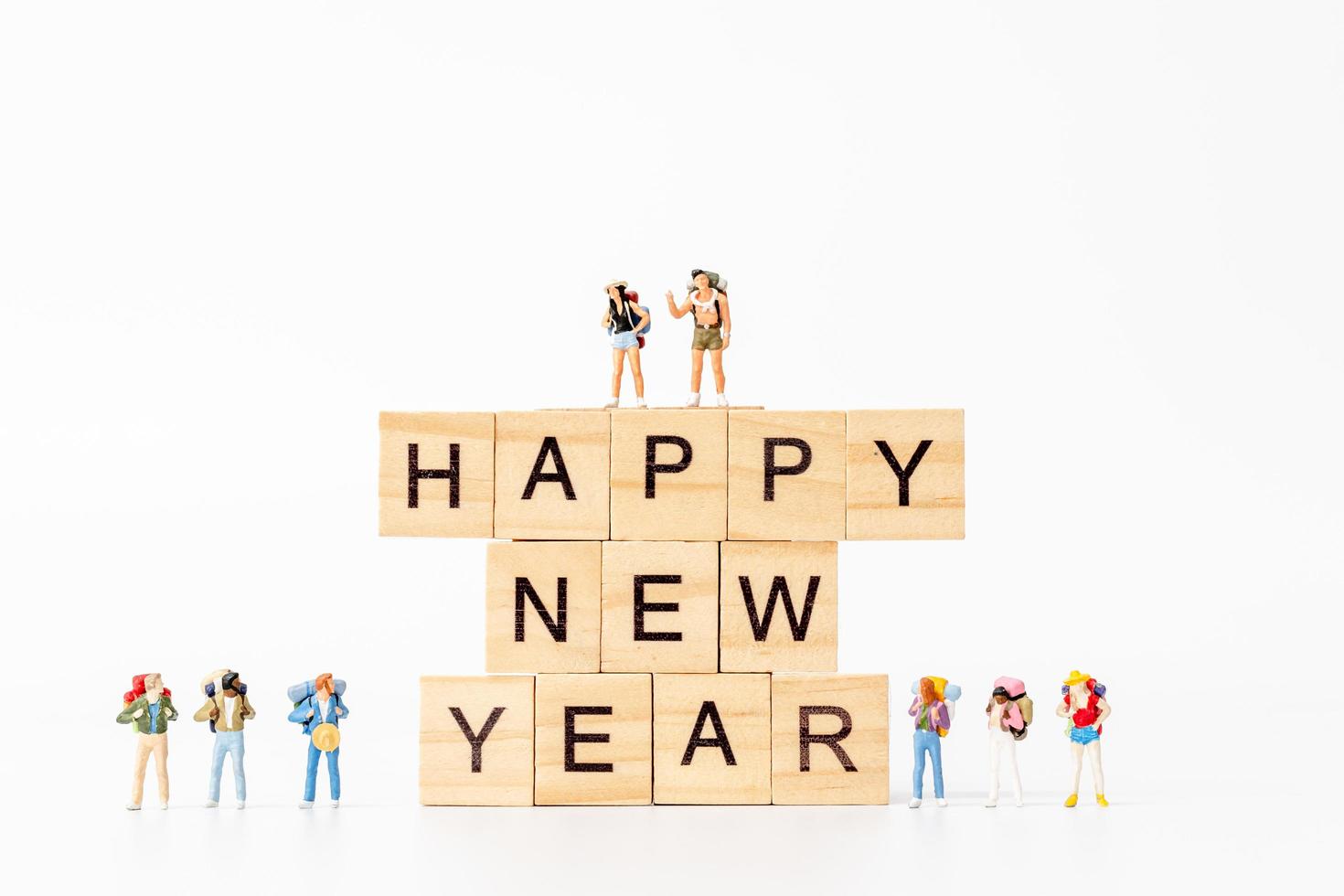 Miniature people on wooden blocks with the text Happy New Year on a white background photo