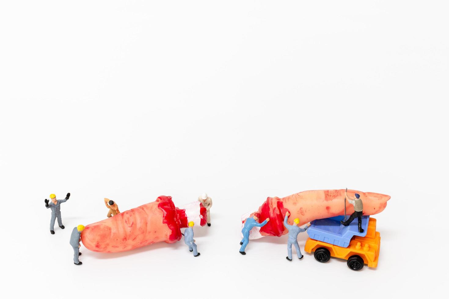 Miniature workers teaming up to create Halloween party props on a white background photo