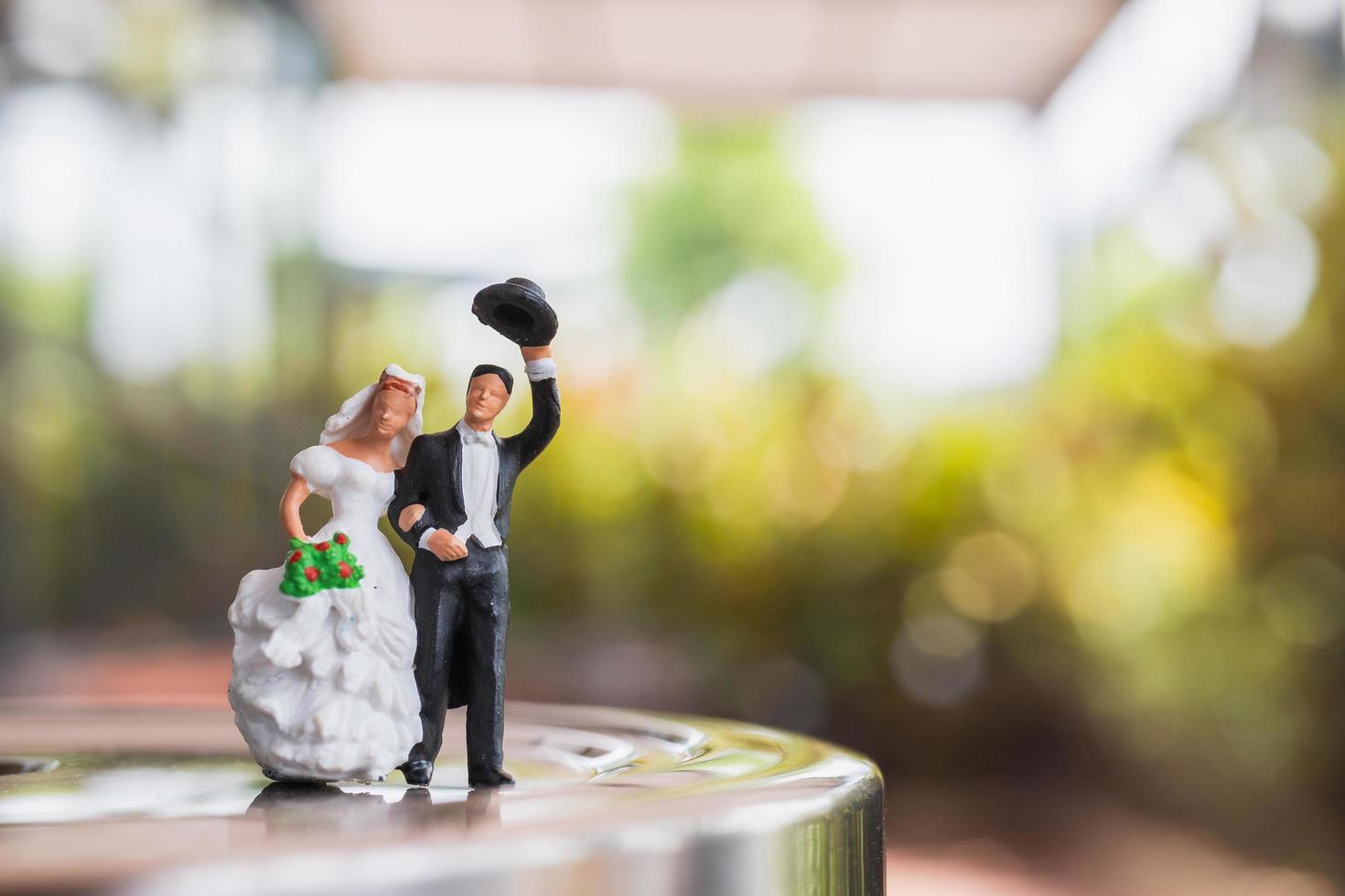 Miniature bride and groom couple standing on a stage, wedding concept photo