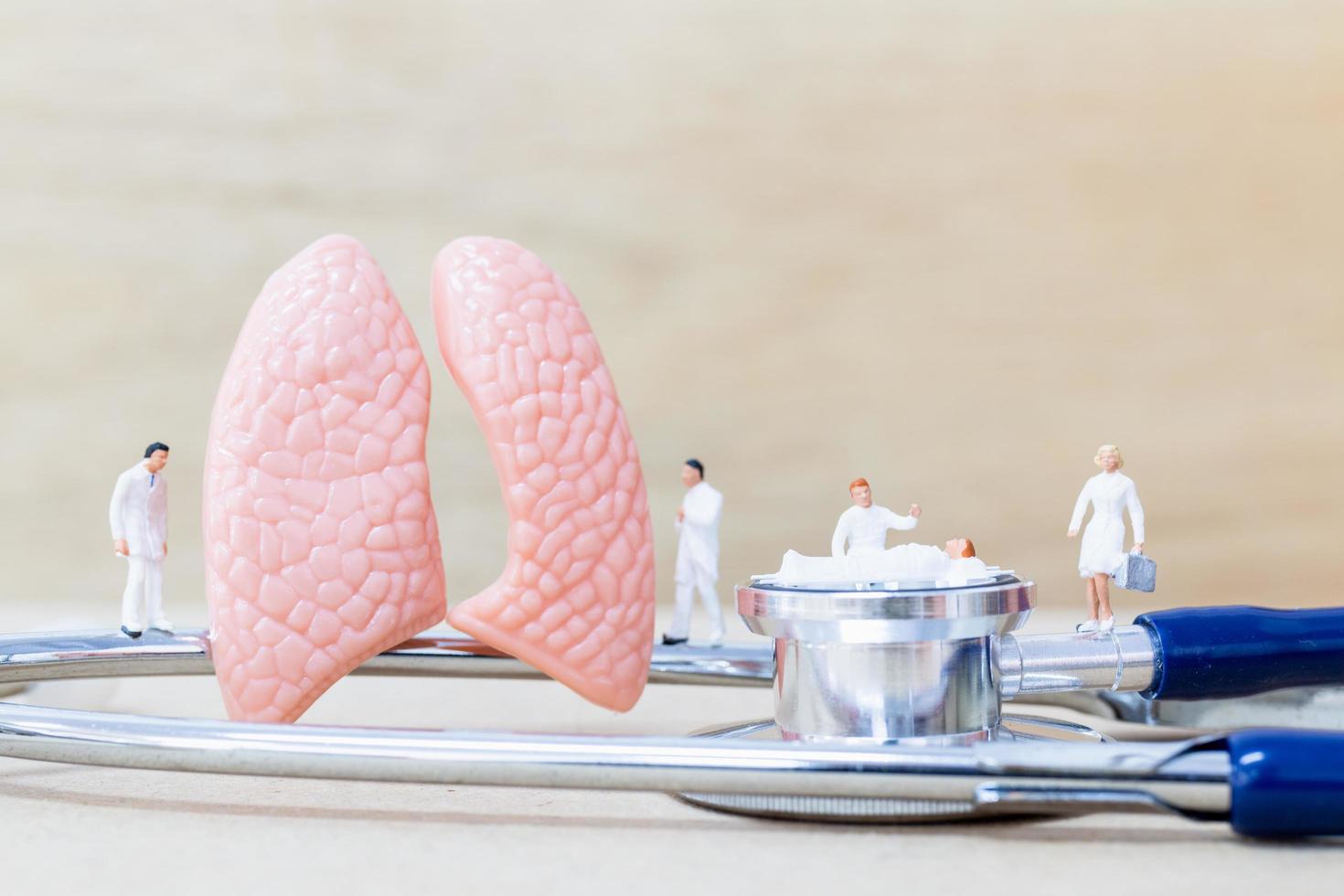 Miniature doctors and nurses observing and discussing about the human lungs, virus and bacteria-infection concept photo