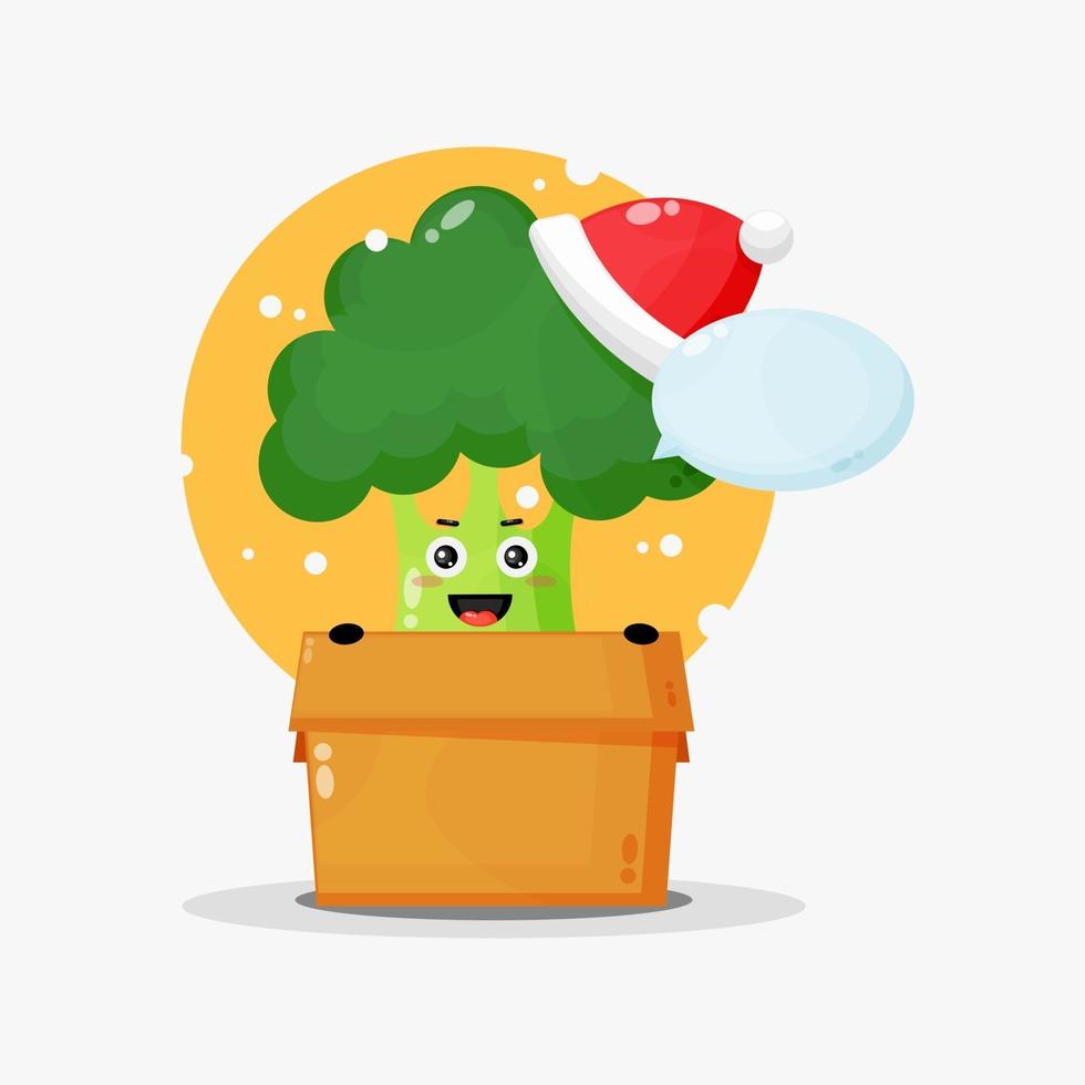 Linda mascota de brócoli en una caja con un sombrero de navidad vector