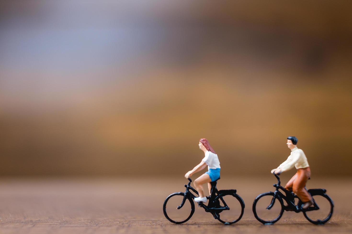 Miniature travelers standing on a wooden background, travel concept photo