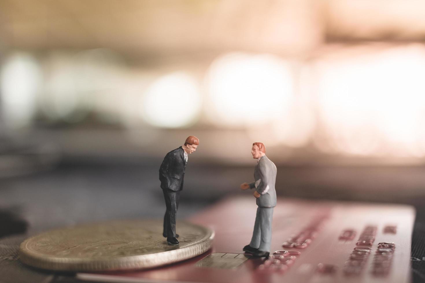 Miniature businessmen standing on a coin, business and finance concept photo
