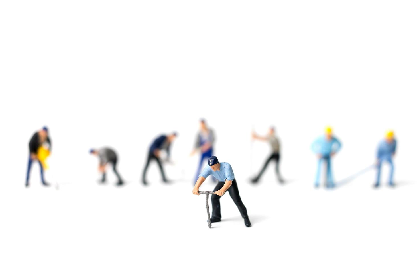 Miniature workers holding tools on a white background, construction concept photo