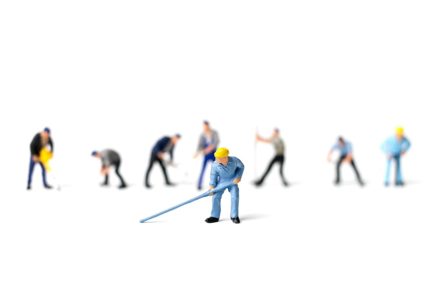 Miniature workers holding tools on a white background, construction concept photo