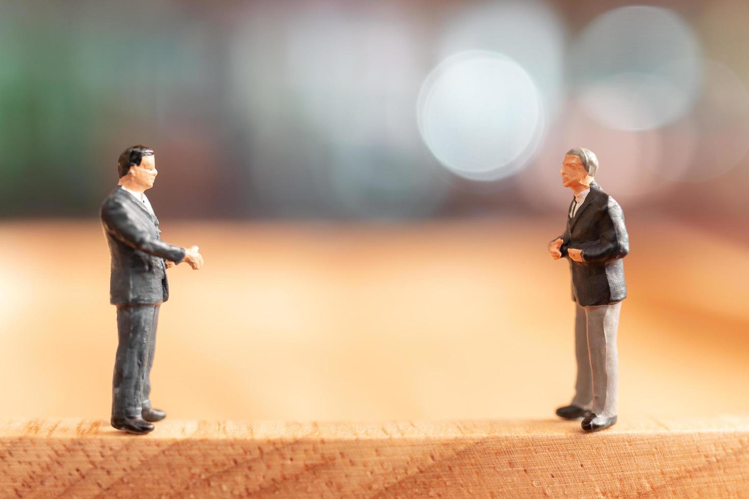 Miniature businessmen standing and thinking with a colorful background photo