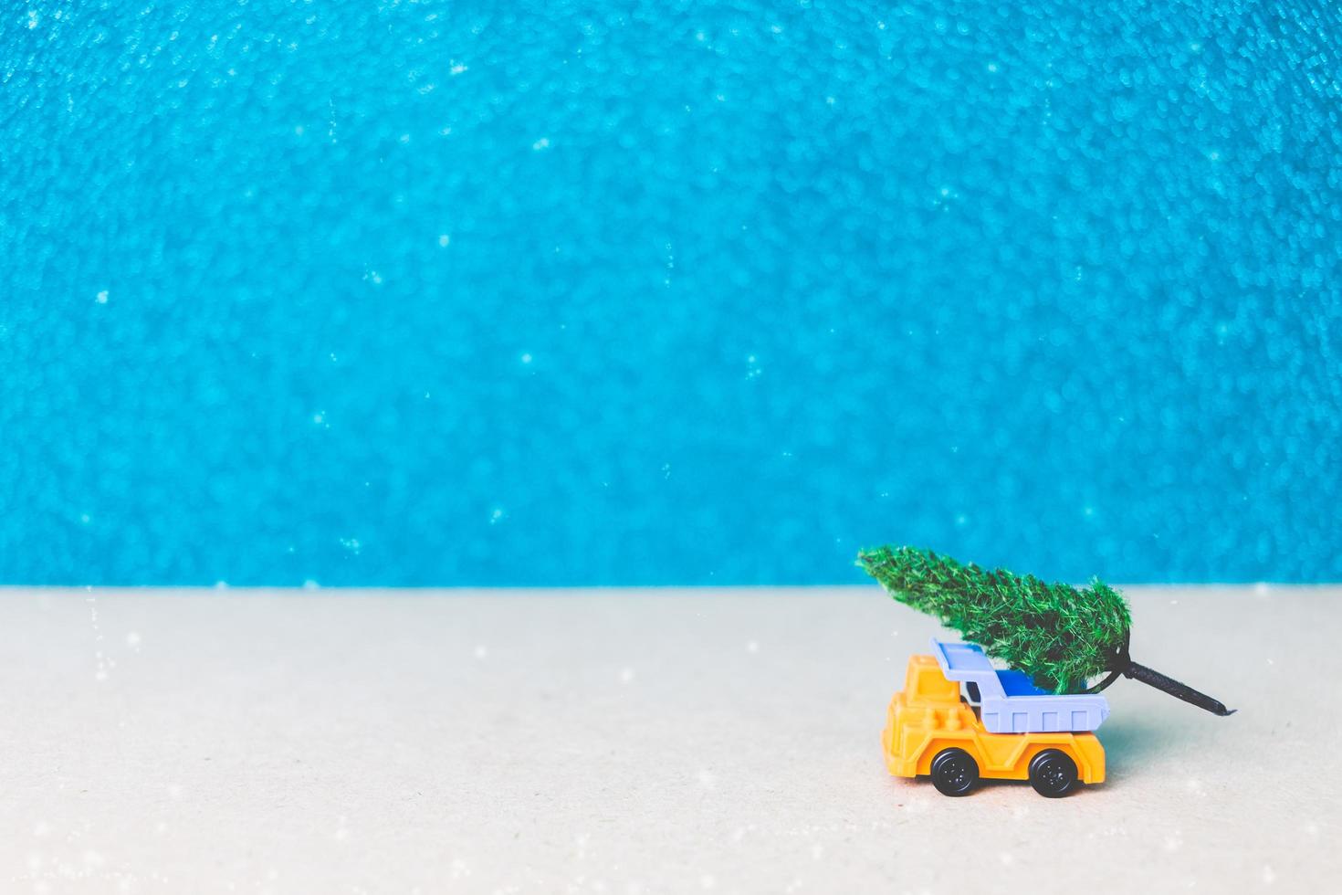 árbol de navidad en un coche en miniatura, concepto de celebración de la temporada navideña foto