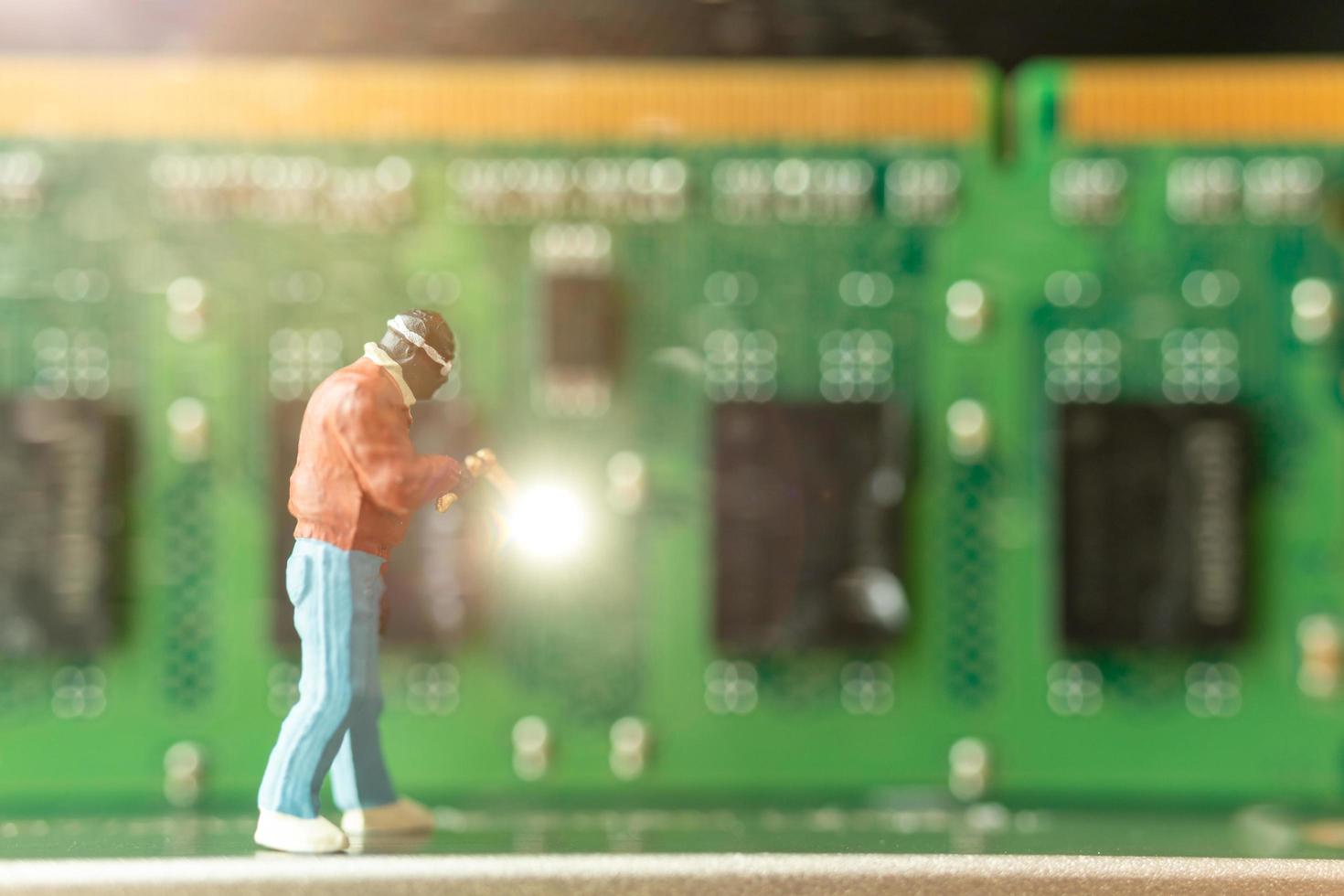 Miniature computer engineer repairing computer hardware, technology concept photo
