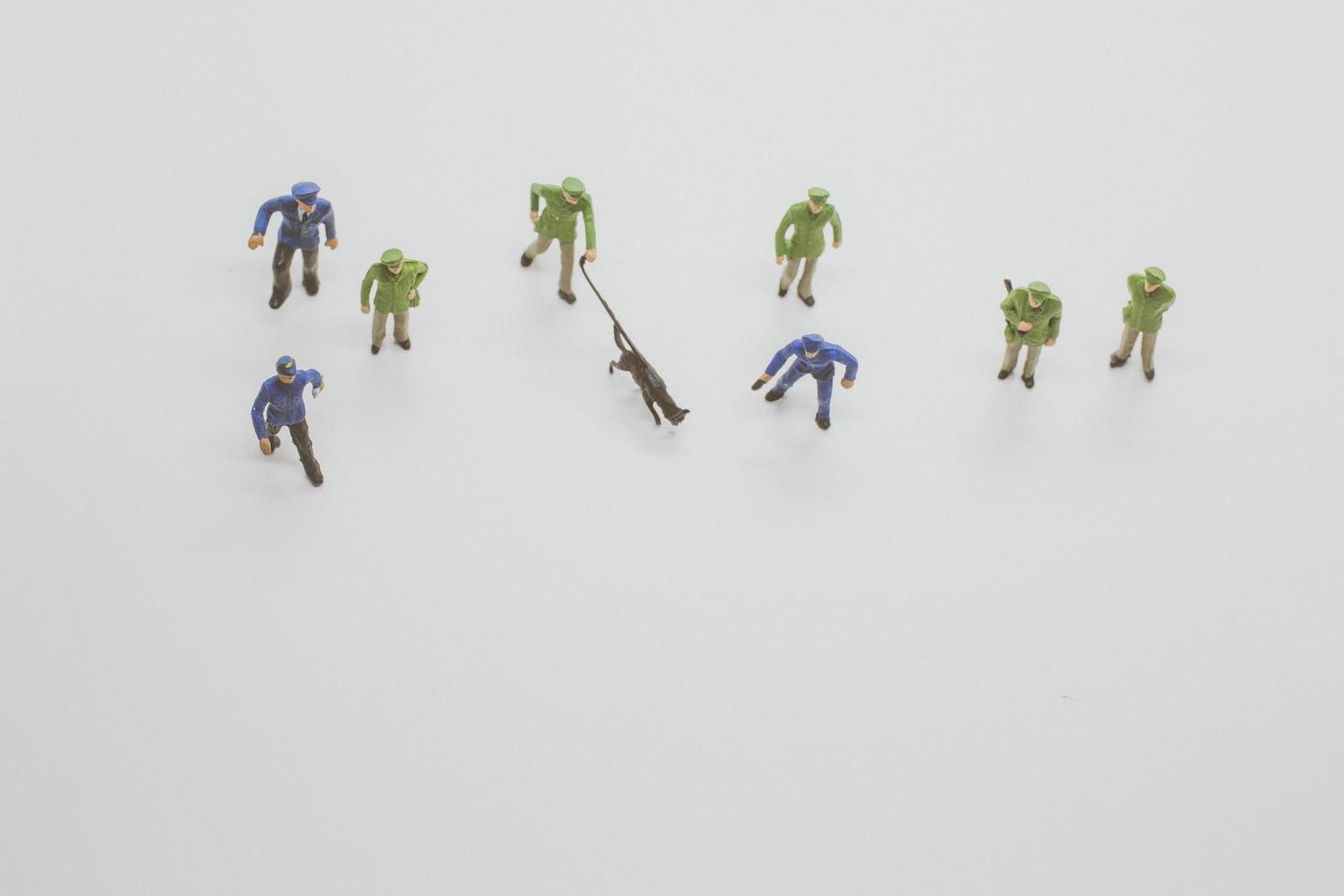 Miniature police officers with police dogs sniffing evidence on a white background photo