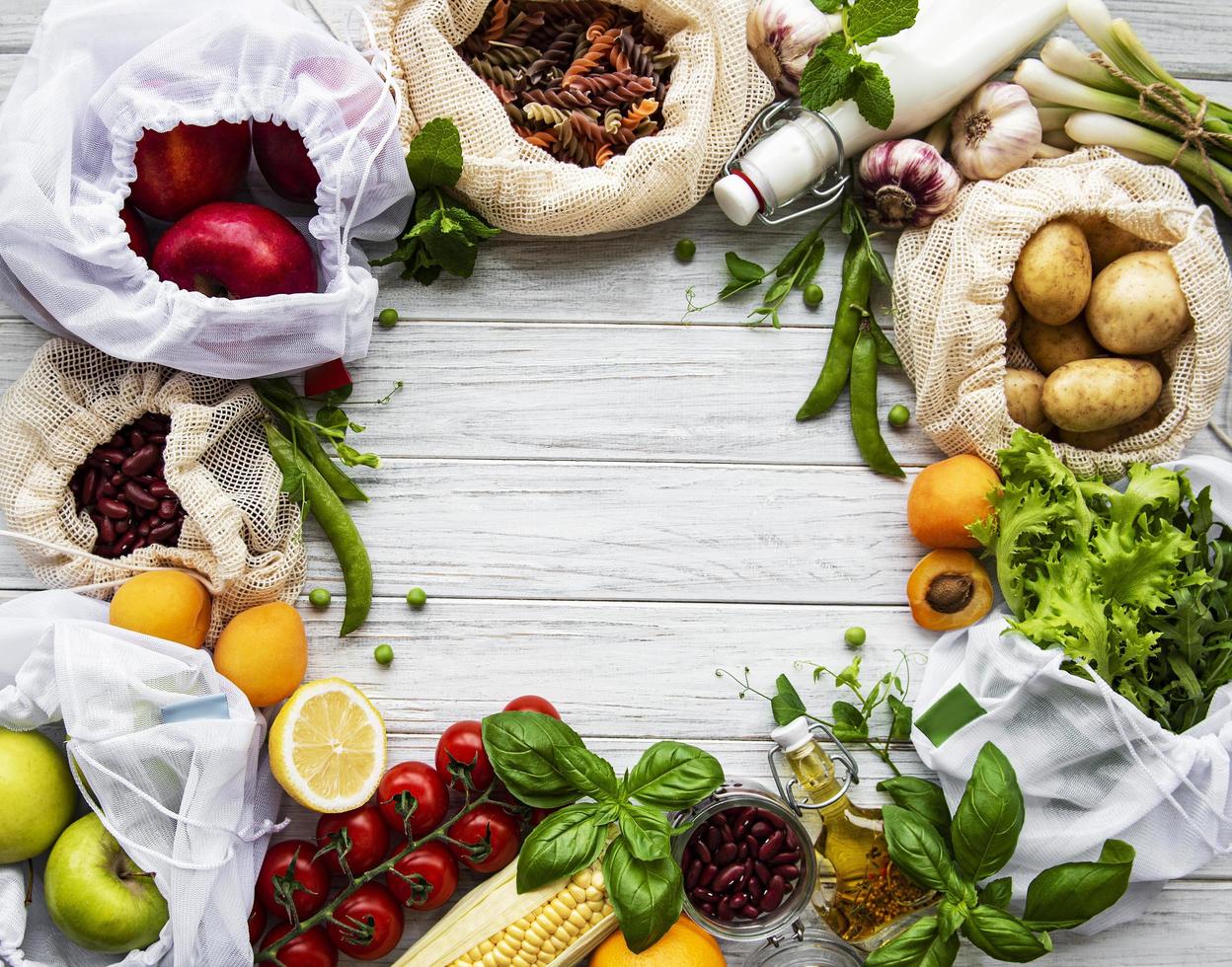 Varias hortalizas, cereales, pastas y frutas orgánicas de la granja en bolsas de supermercado de envases reutilizables foto