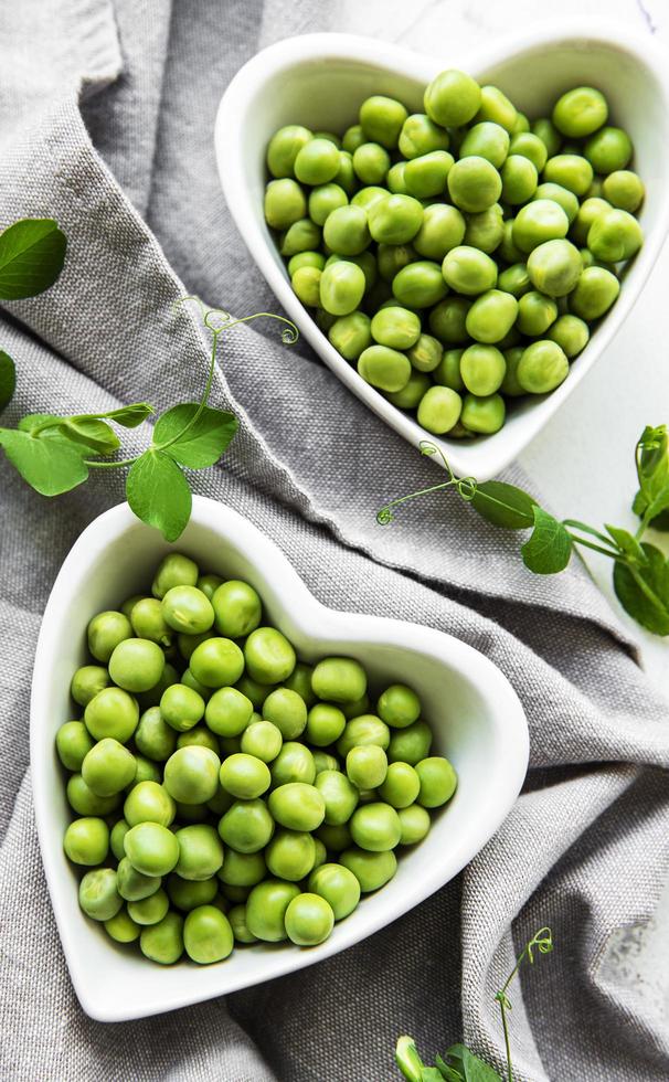 Guisantes en cuencos en forma de corazón sobre un fondo de tela foto