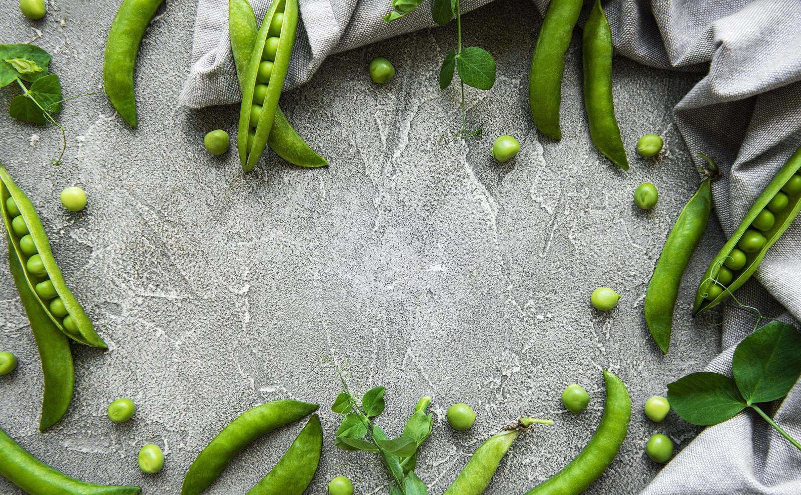 Pods of green peas on a concrete background photo
