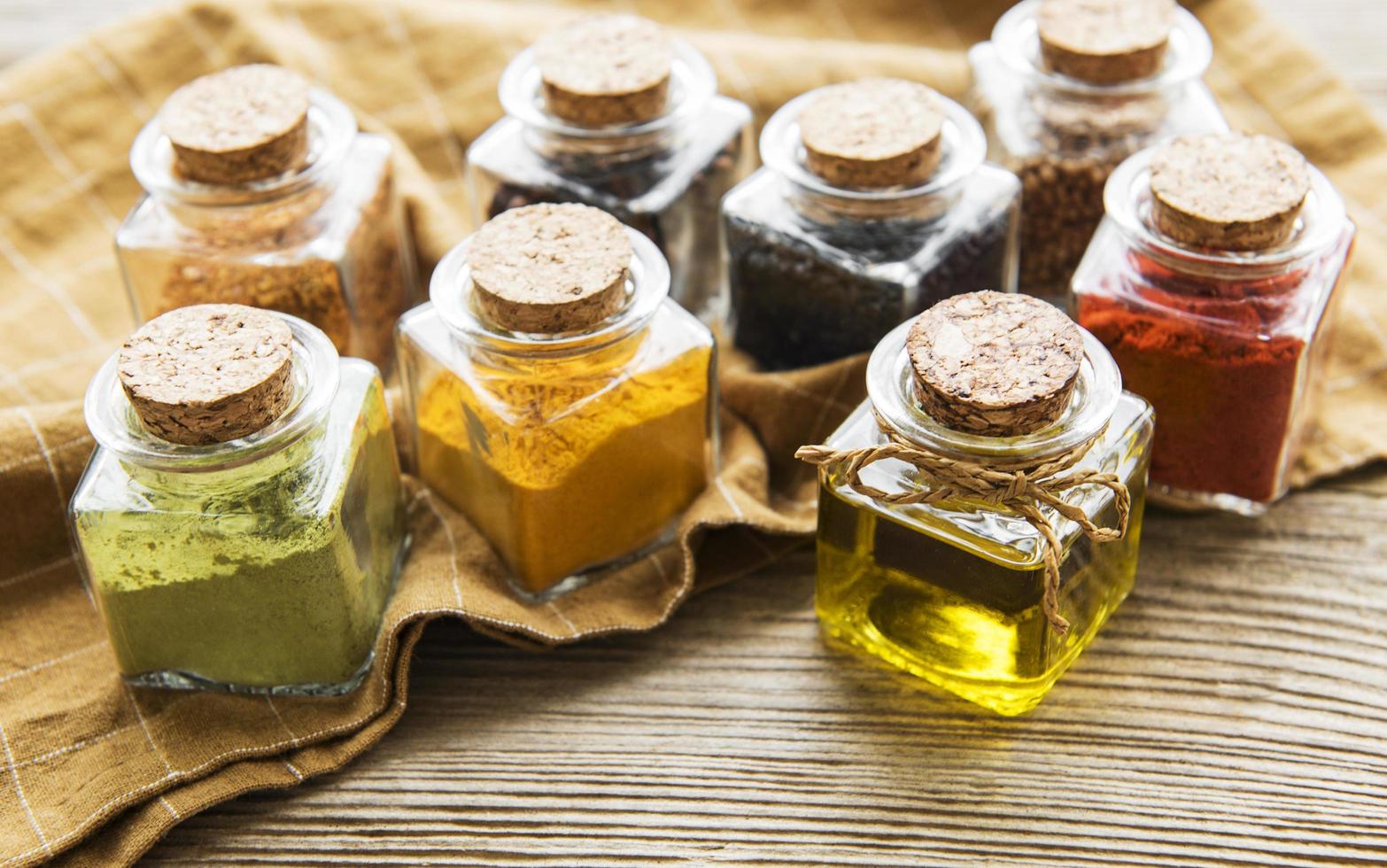 Jars with dried herbs, spices on the table photo