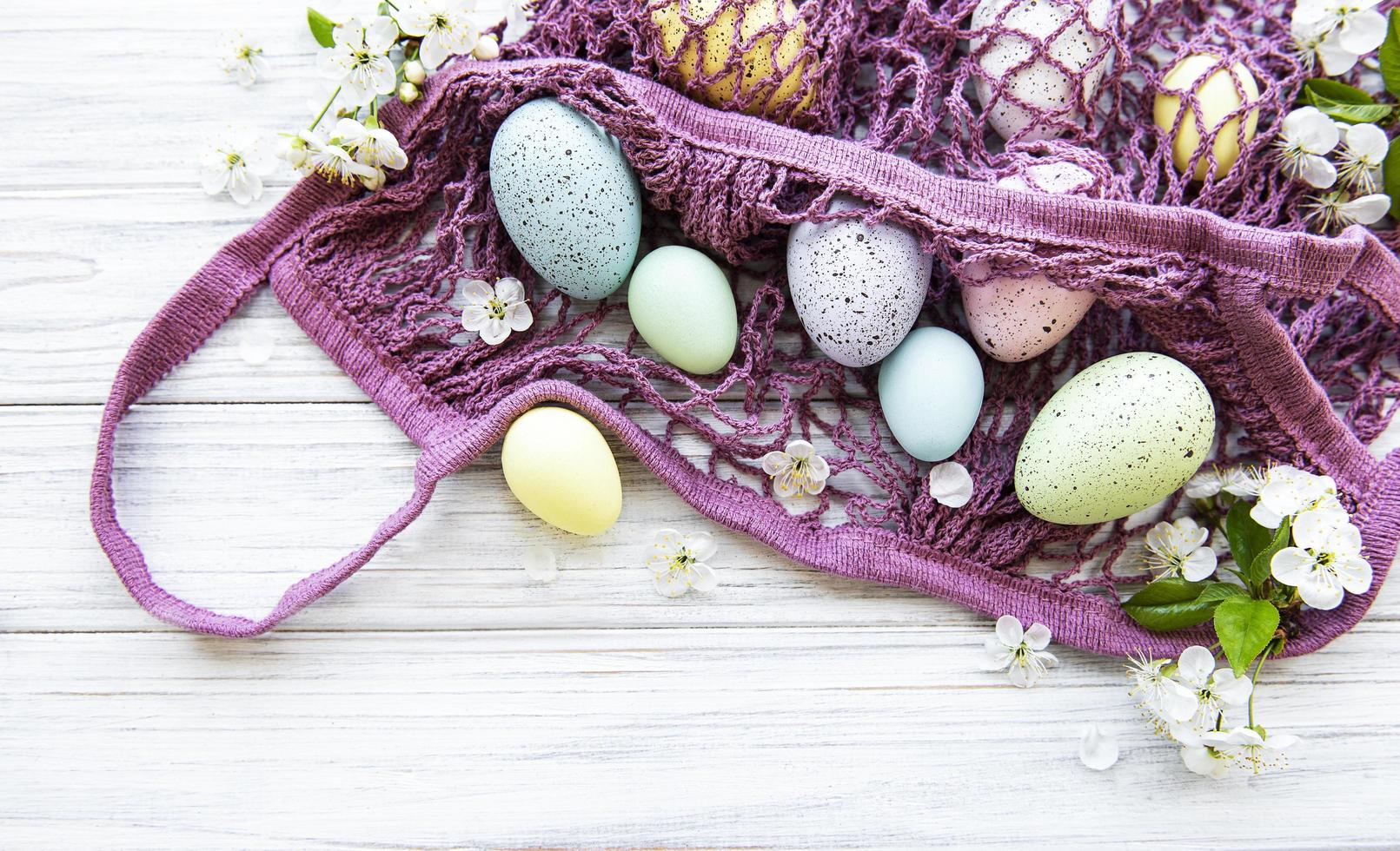 bolsa de hilo con huevos de pascua y flor de primavera foto