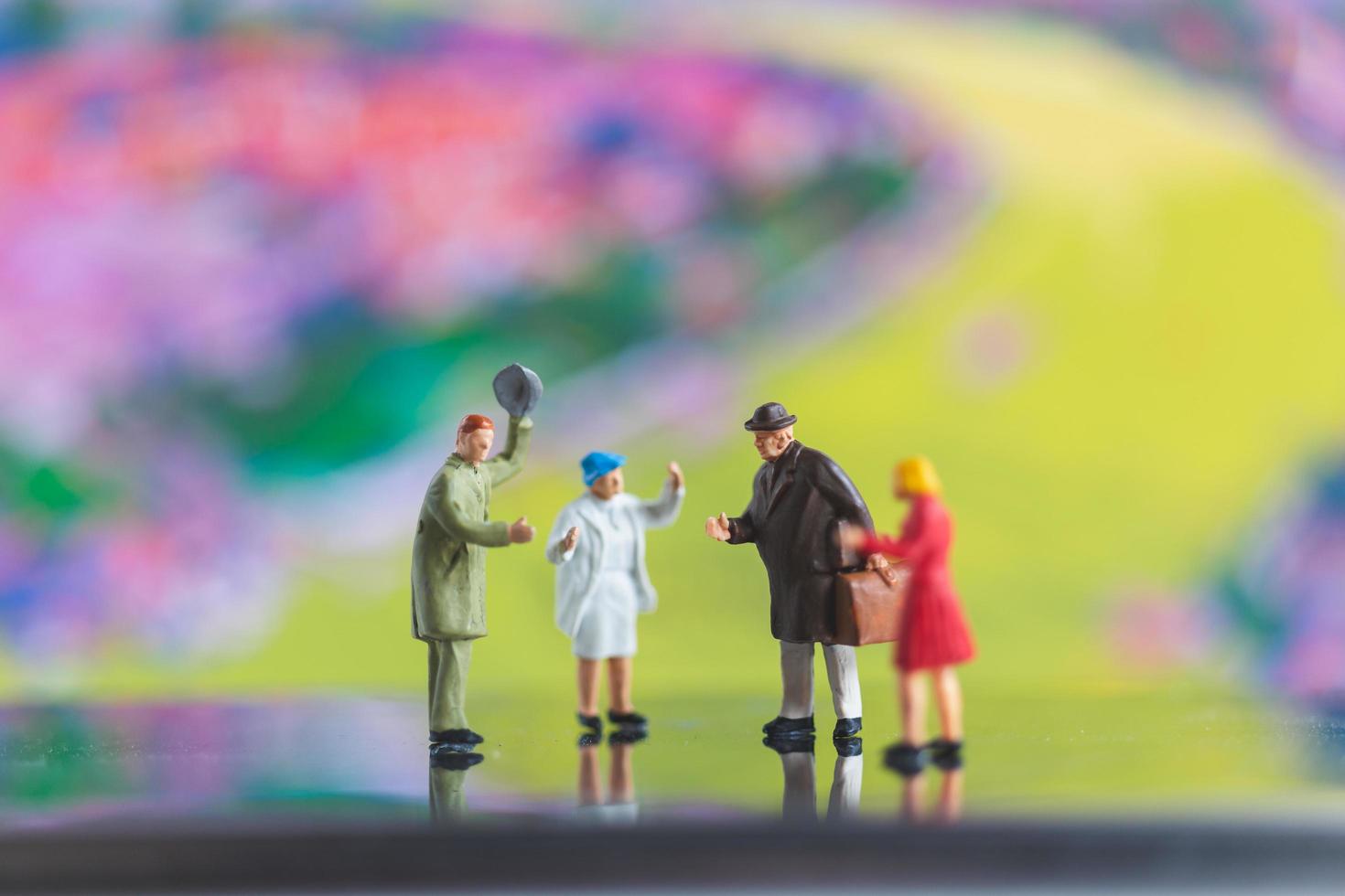 Miniature people handshaking on a colorful background photo