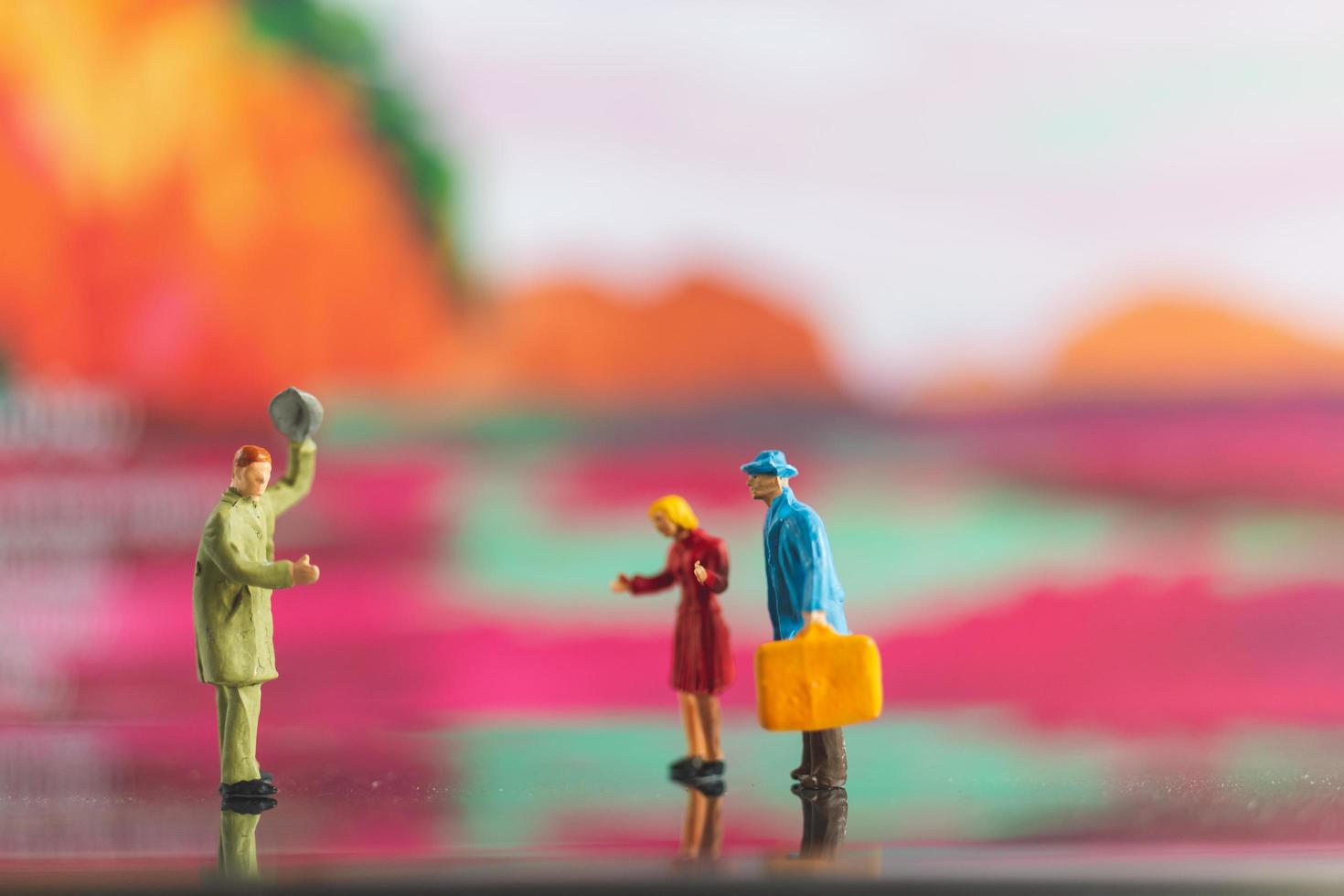 Miniature people handshaking on a colorful background photo