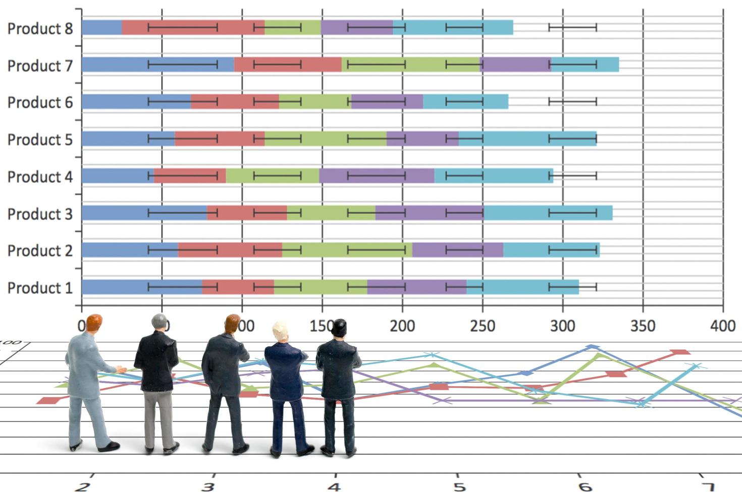 Miniature businessmen standing with charts on a white background photo