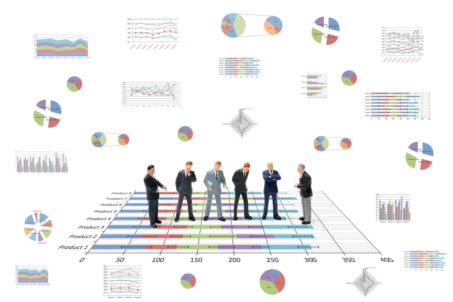 Miniature businessmen standing with charts on a white background photo
