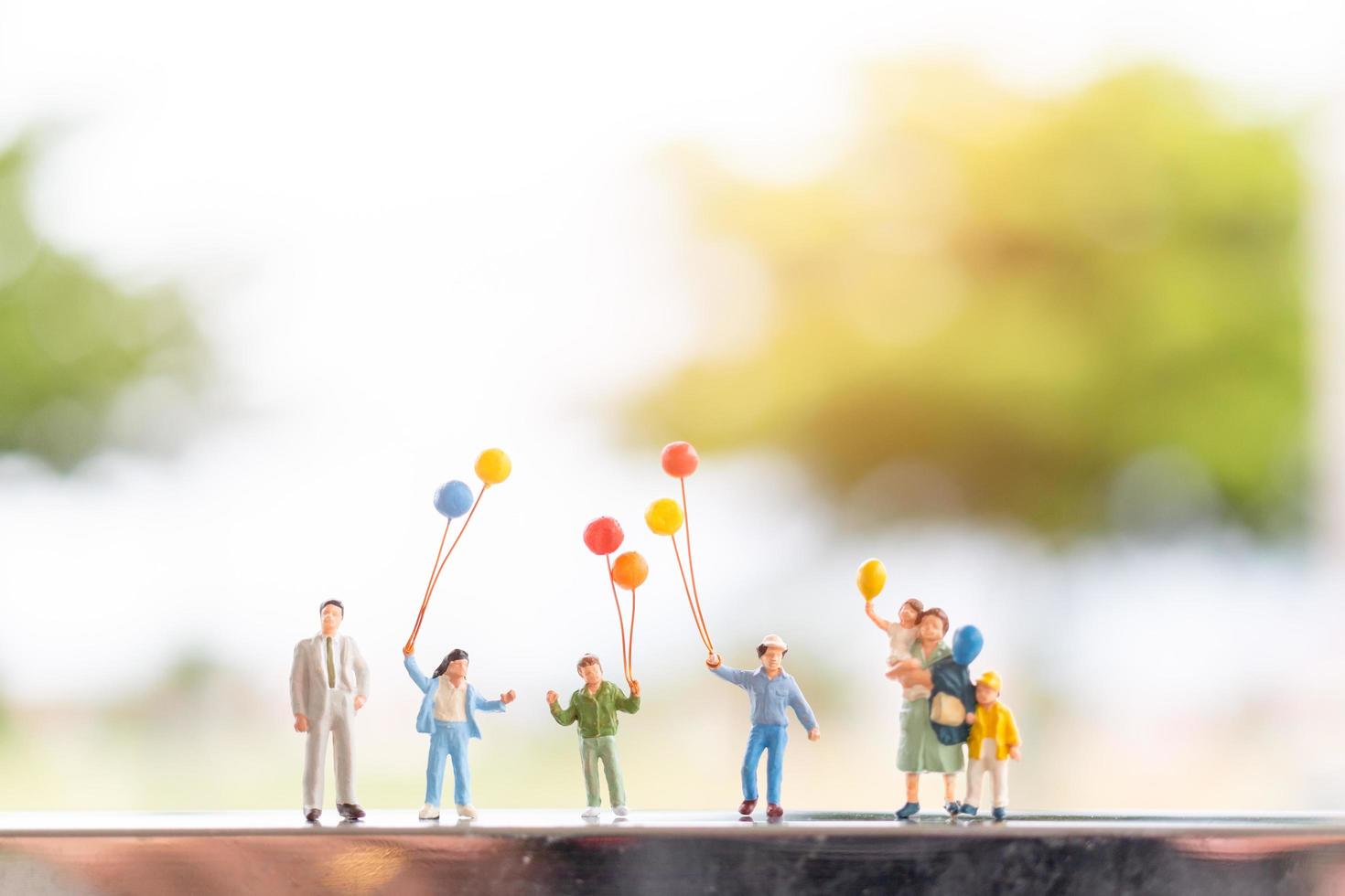 familia en miniatura con globos, relaciones familiares felices y concepto de tiempo libre sin preocupaciones foto