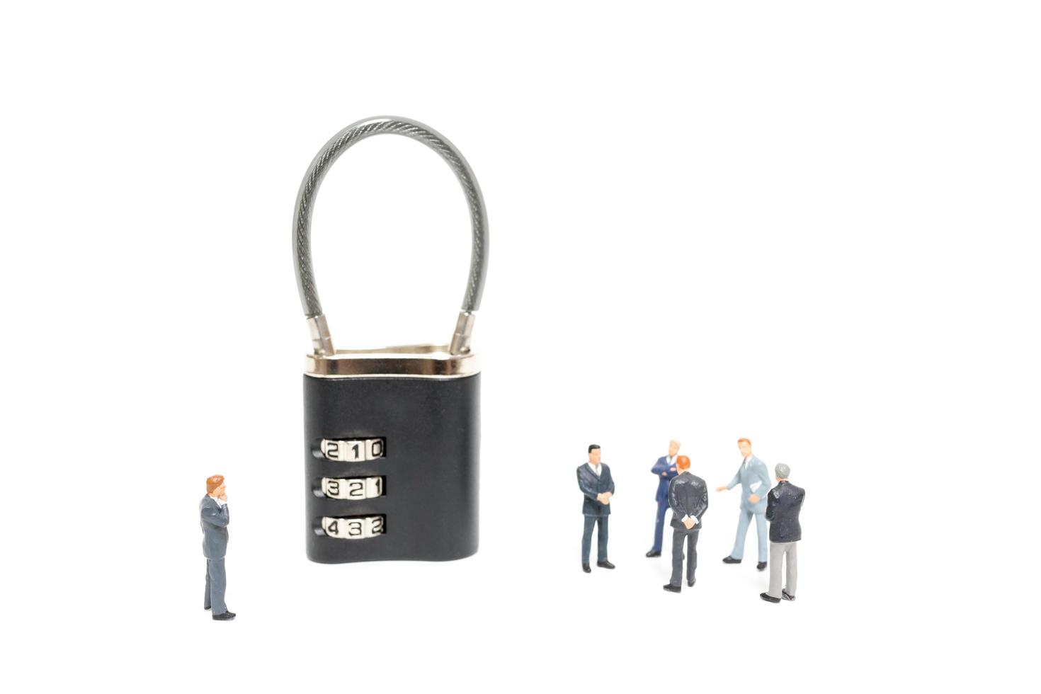 Miniature businessmen helping to unlock the password on a lock, business solution concept photo