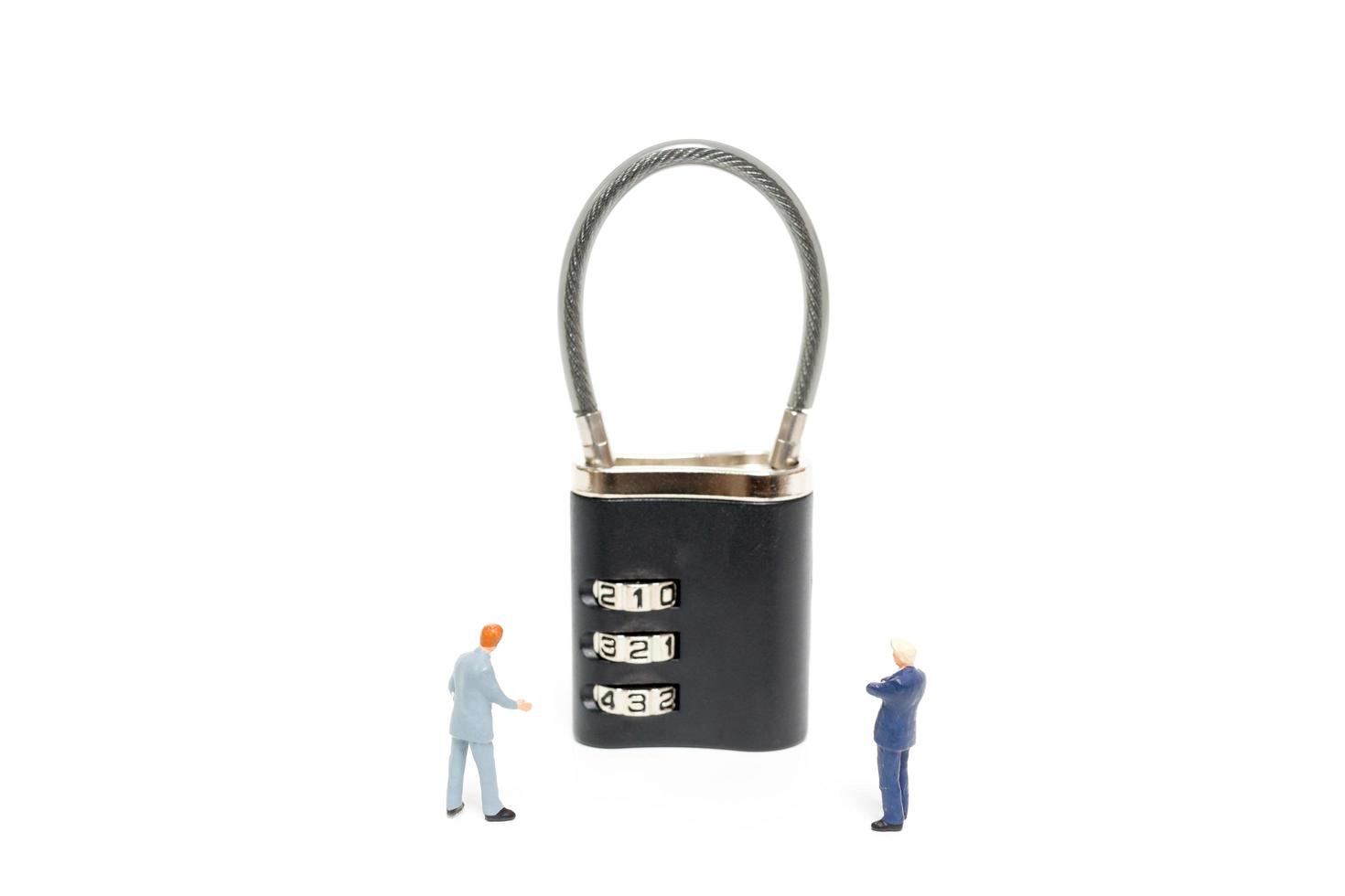 Miniature businessmen helping to unlock the password on a lock, business solution concept photo