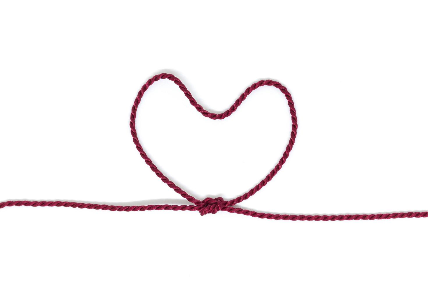 Heart-shaped knot on a rope on a white background photo