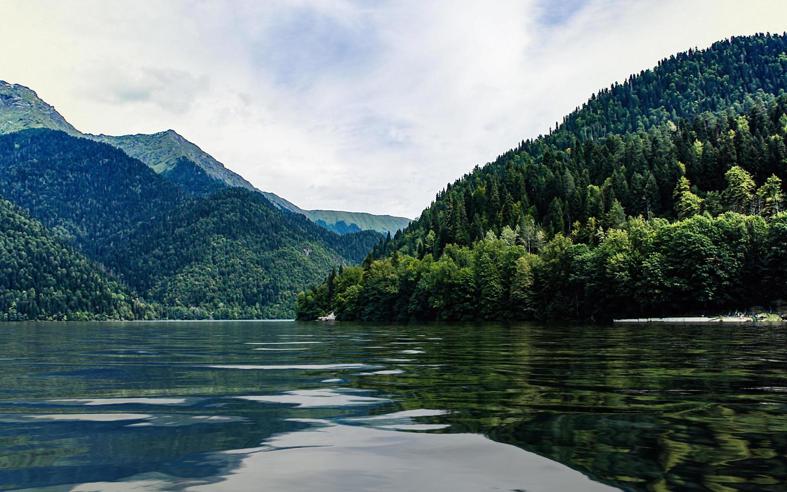 Landscape with Lake Ritsa and mountains with a cloudy blue sky photo