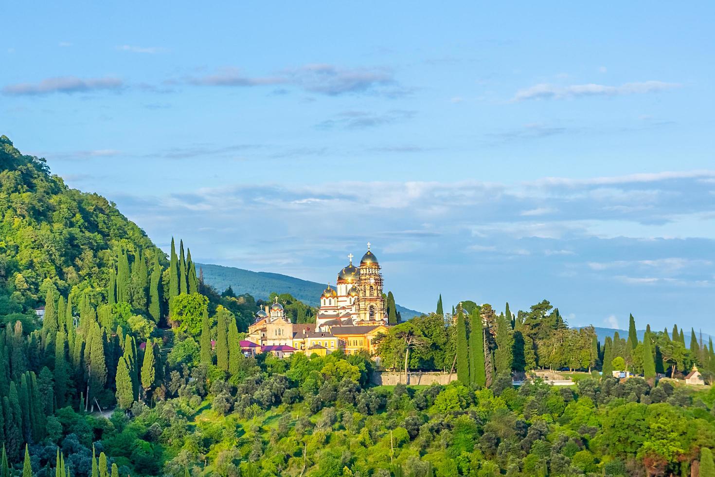 Landscape with a view of the New Athos Monastery with cloudy blue sky in Abkhazia, Georgia photo